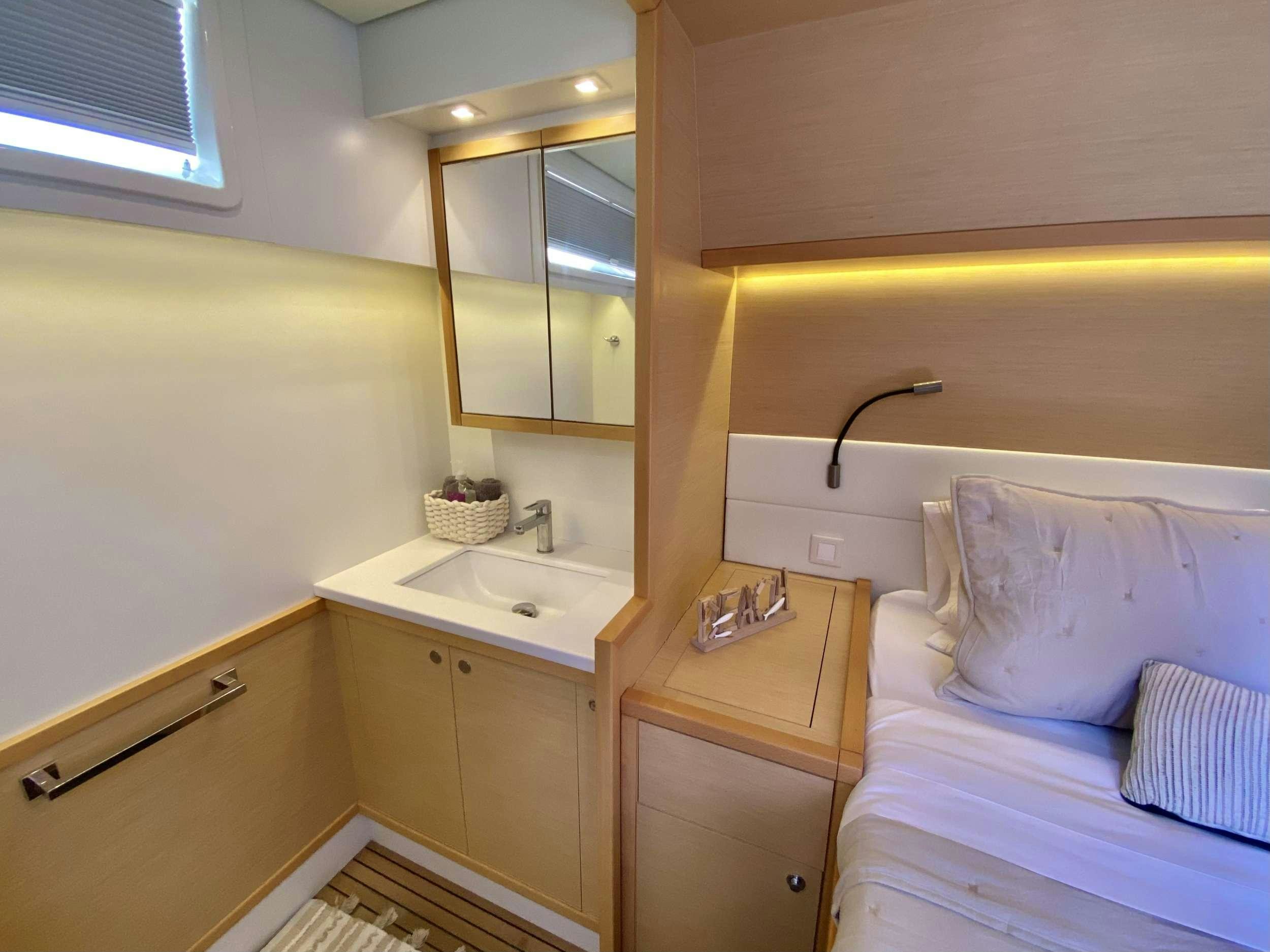 a bedroom with a bed and a sink aboard CHAMPAGNE L52 Yacht for Charter