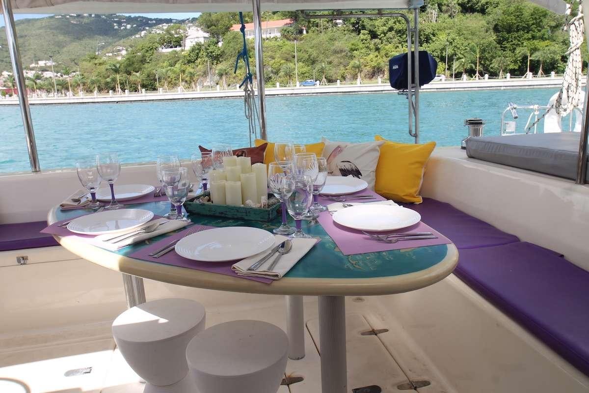 a table set with place settings aboard PURPLE PELICAN Yacht for Charter