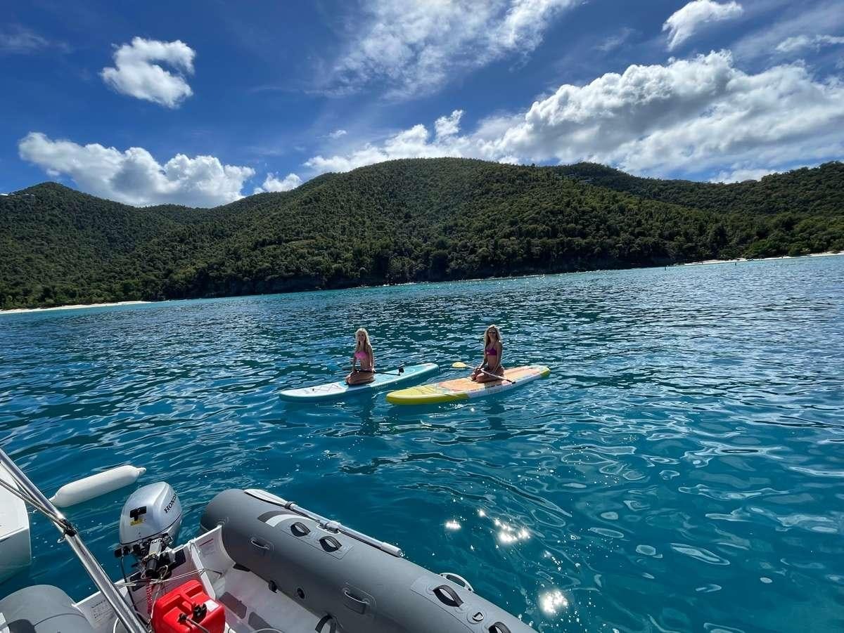 people on kayaks in water aboard CELAVIE Yacht for Charter