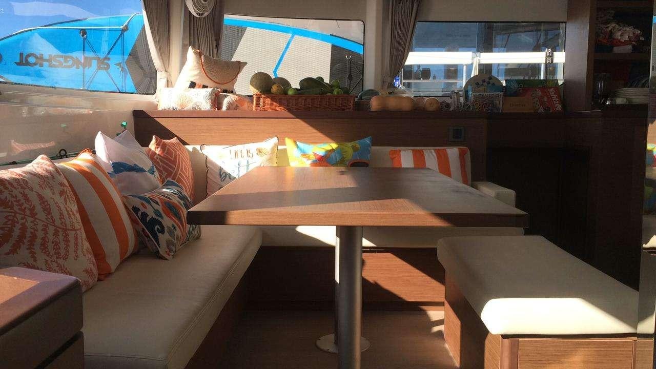 a couch and a table in a room aboard CELAVIE Yacht for Charter