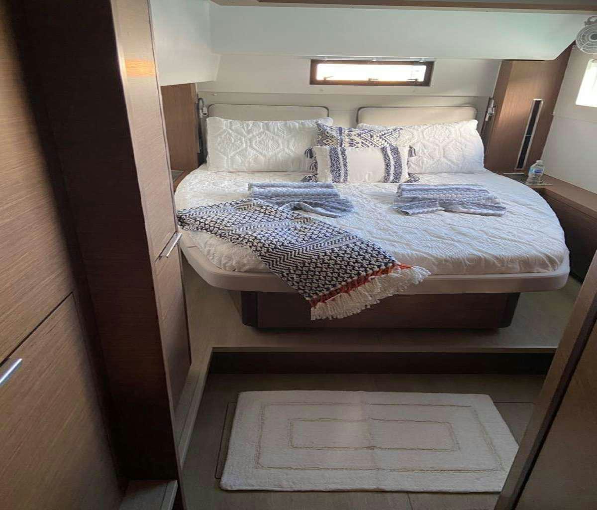a bed with a white sheet aboard CELAVIE Yacht for Charter