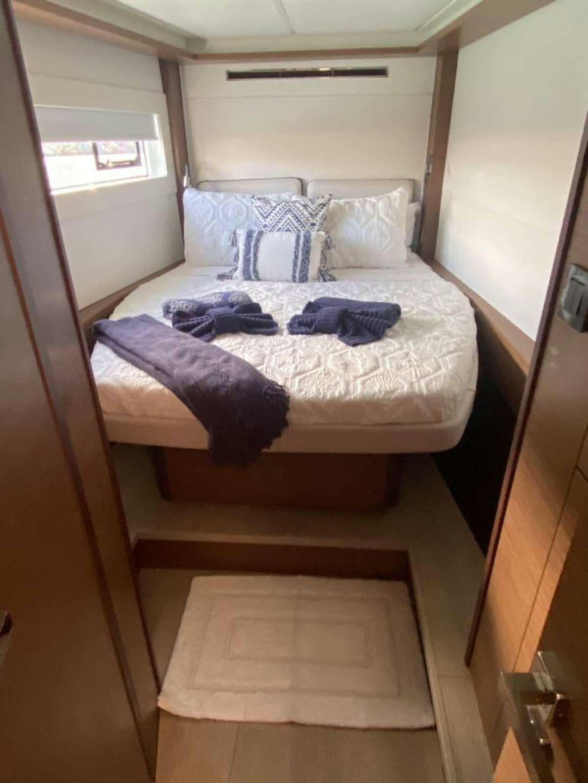 a bed with blue sheets aboard CELAVIE Yacht for Charter