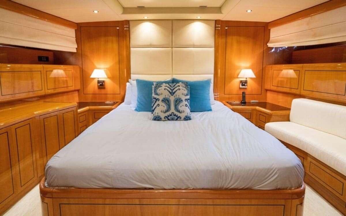 a bed with blue pillows aboard HAPPY Yacht for Charter
