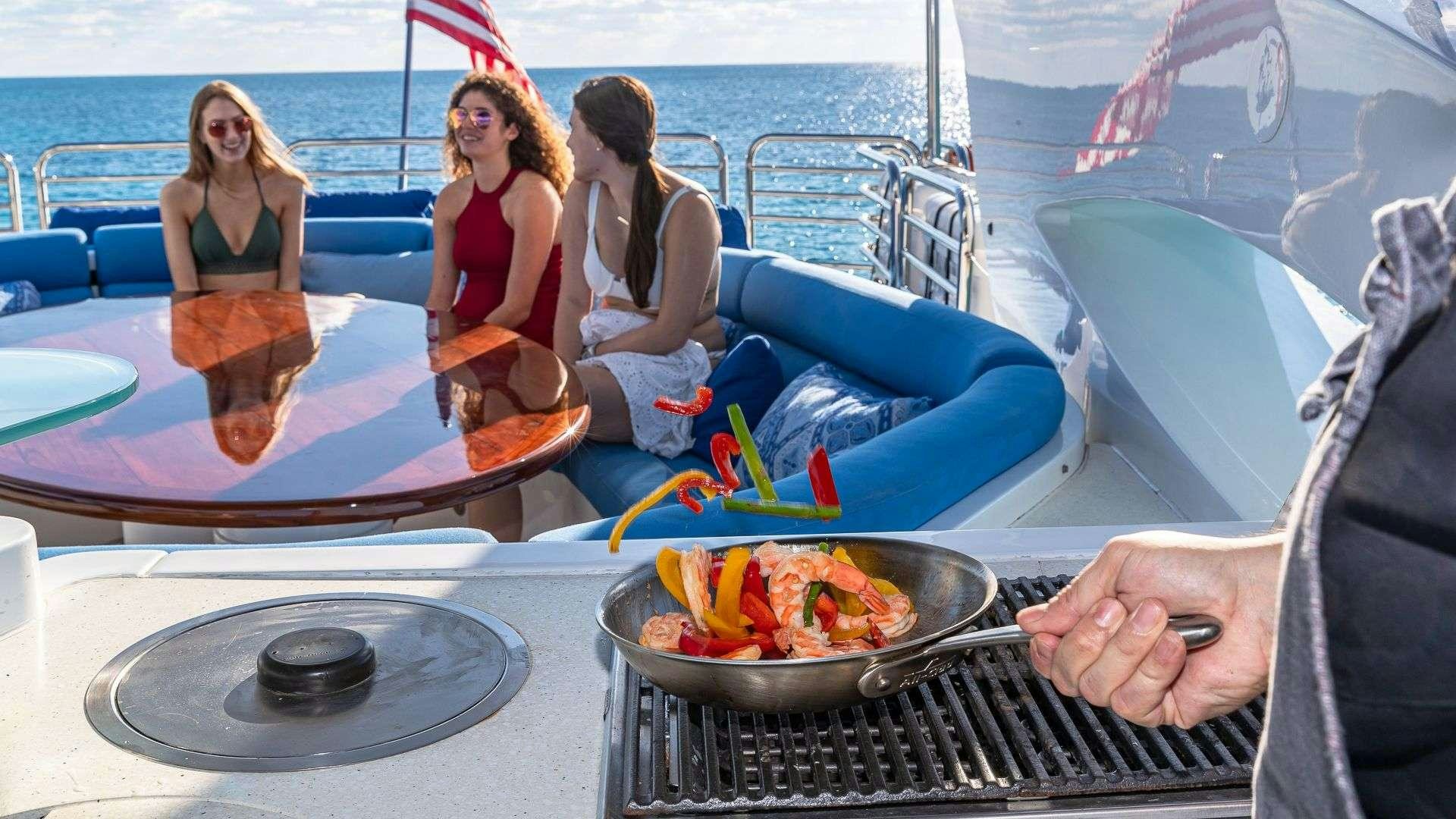 a group of women sitting on a boat with a bowl of food aboard KEFI Yacht for Charter