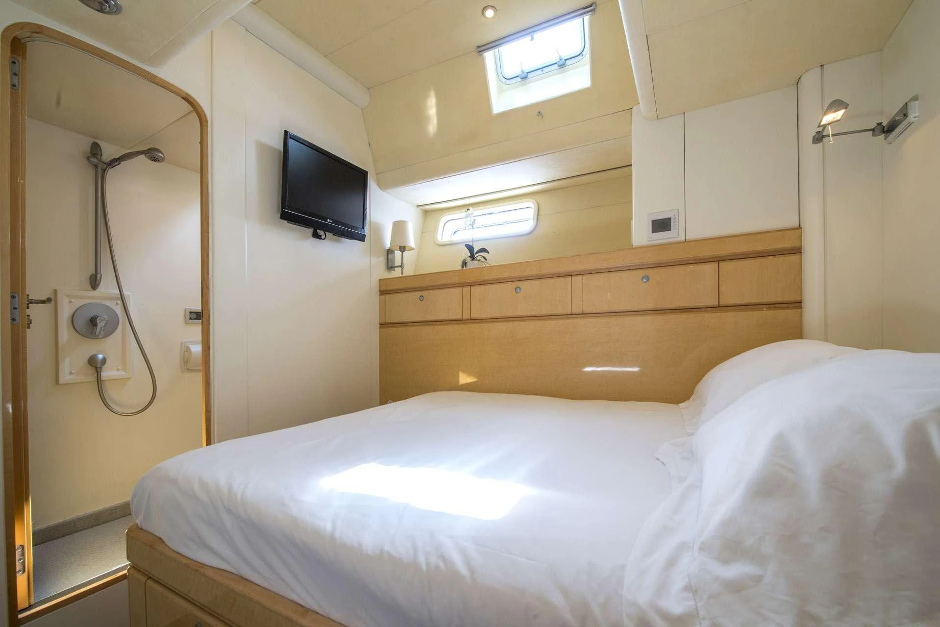 a bed with a mirror on the wall aboard LADY 8 Yacht for Charter