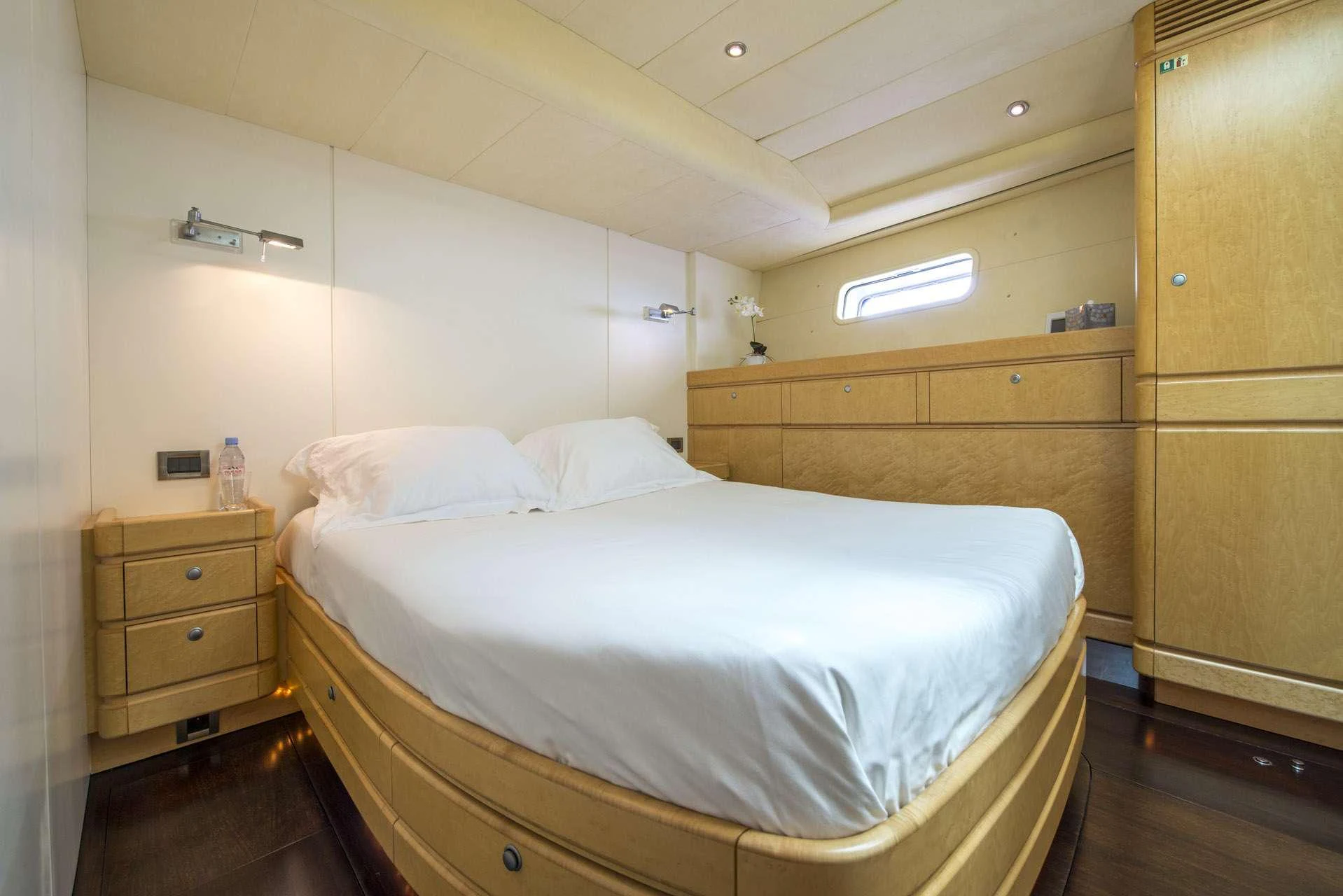 a room with a bed and a dresser aboard LADY 8 Yacht for Charter