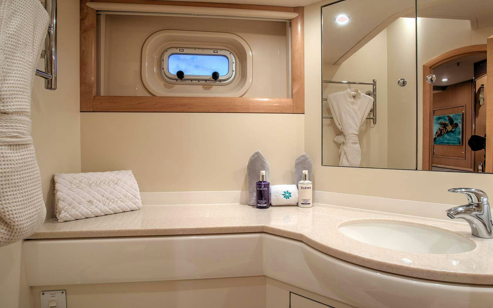 a bathroom with a sink and a mirror aboard DAMA DE NOCHE Yacht for Charter