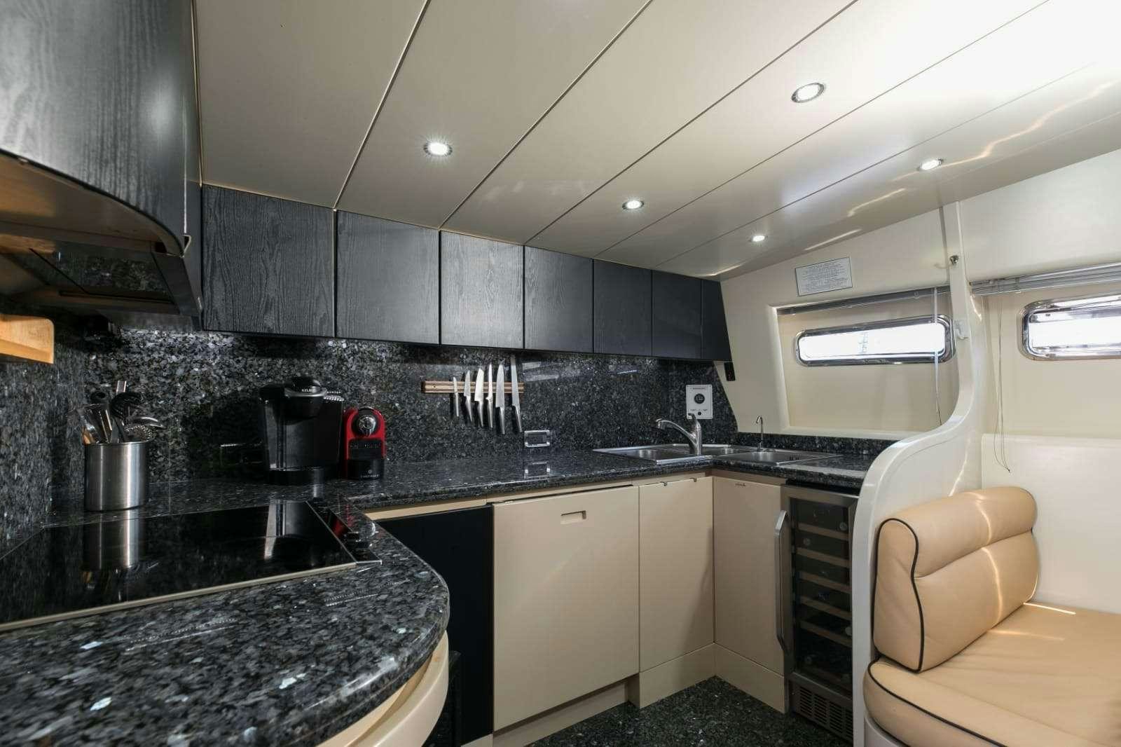 a kitchen with black counter tops aboard 103' CUSTOM BUILD Yacht for Charter