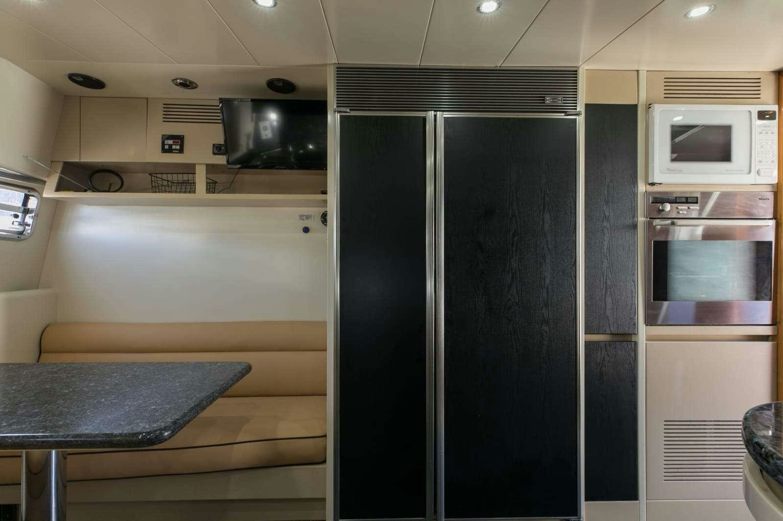 a kitchen with a fridge and microwave aboard 103' CUSTOM BUILD Yacht for Charter