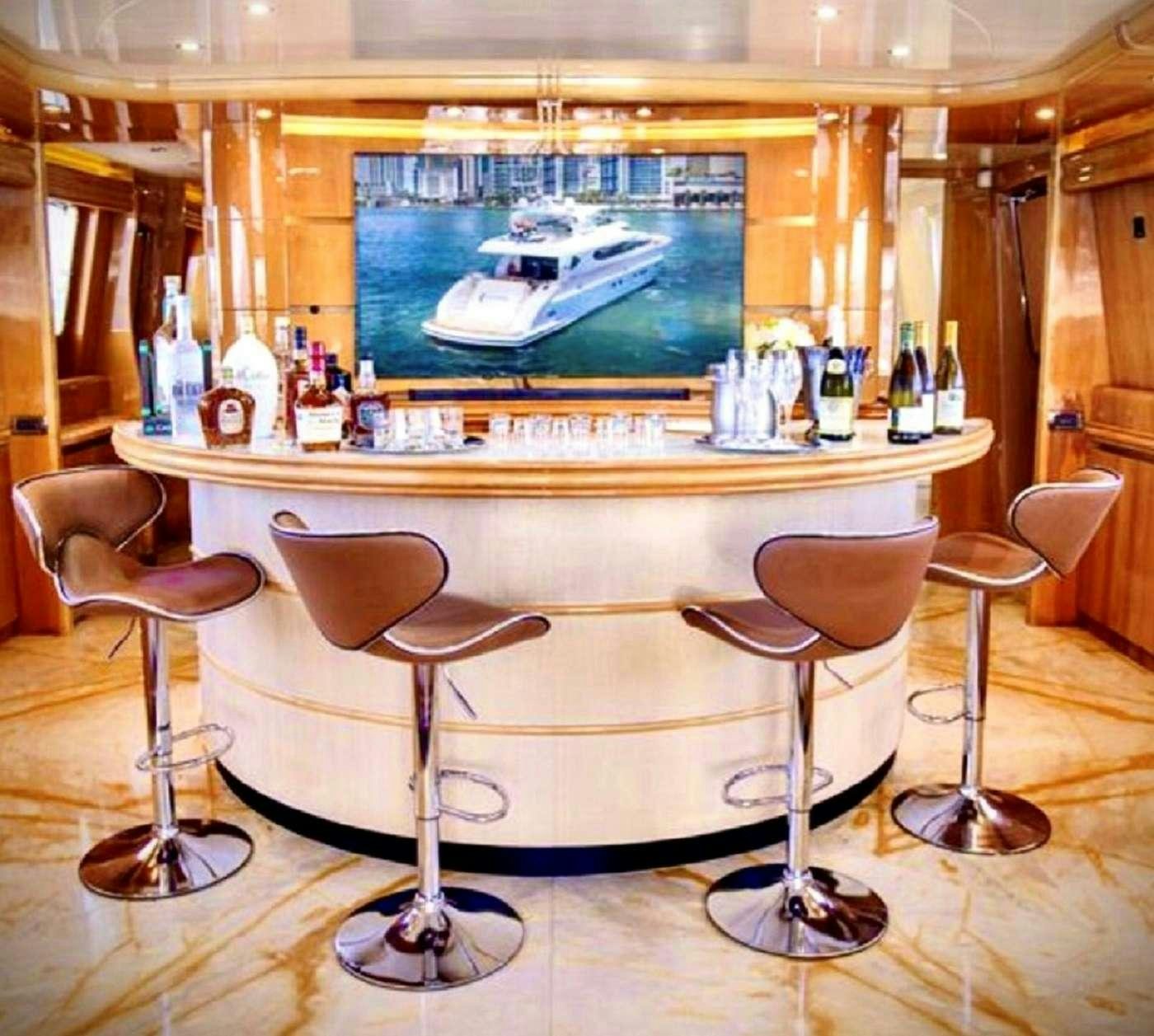 a bar with a television on the wall aboard 103' CUSTOM BUILD Yacht for Charter