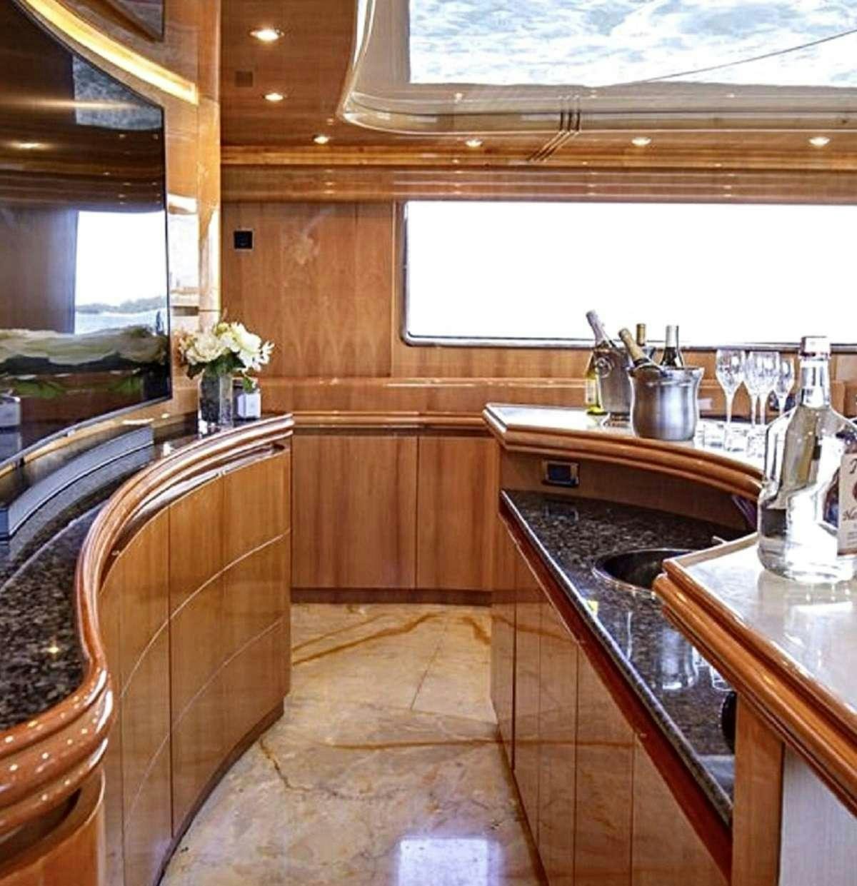 a kitchen with wooden cabinets aboard 103' CUSTOM BUILD Yacht for Charter