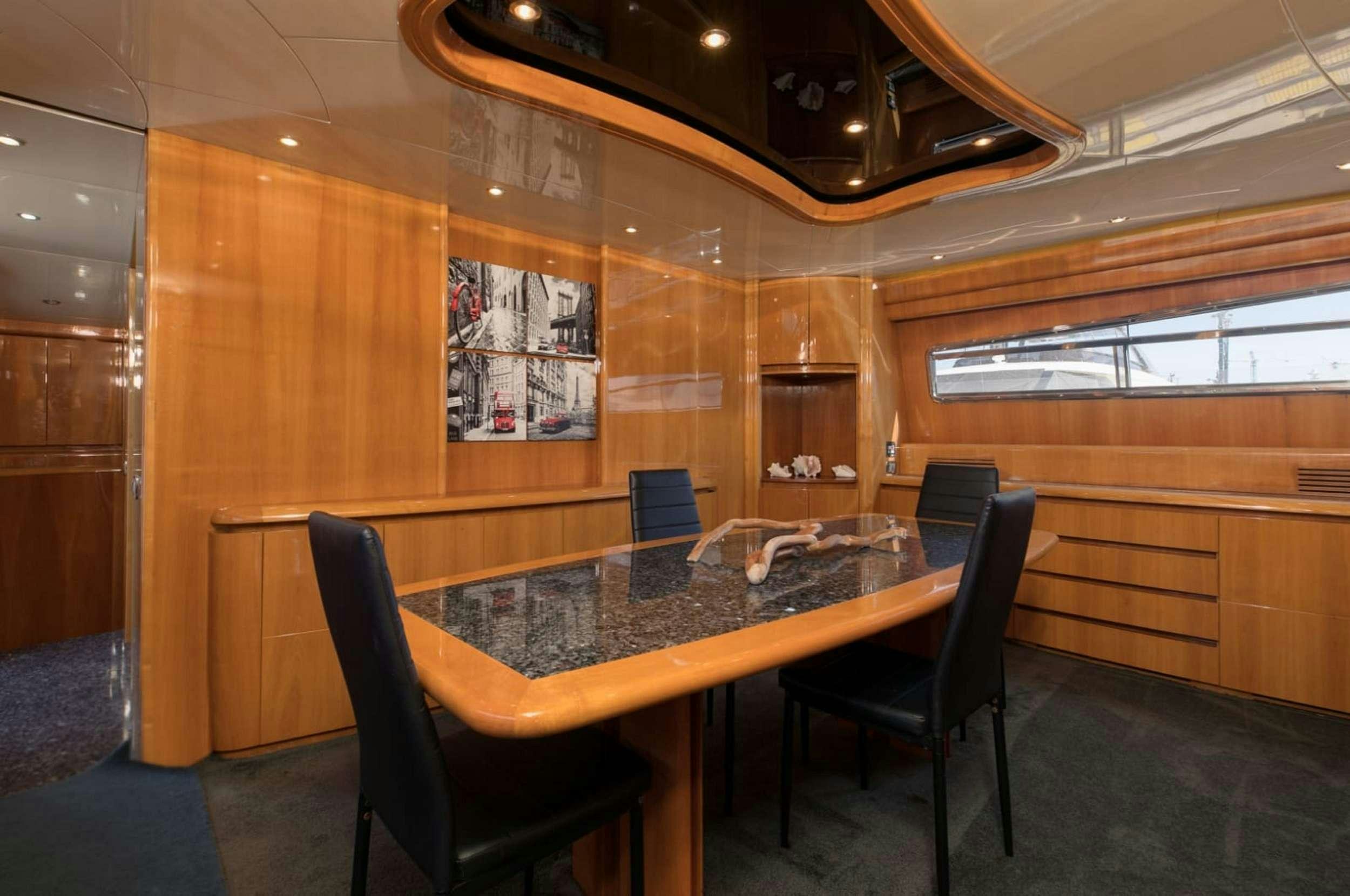 a room with a table and chairs aboard 103' CUSTOM BUILD Yacht for Charter