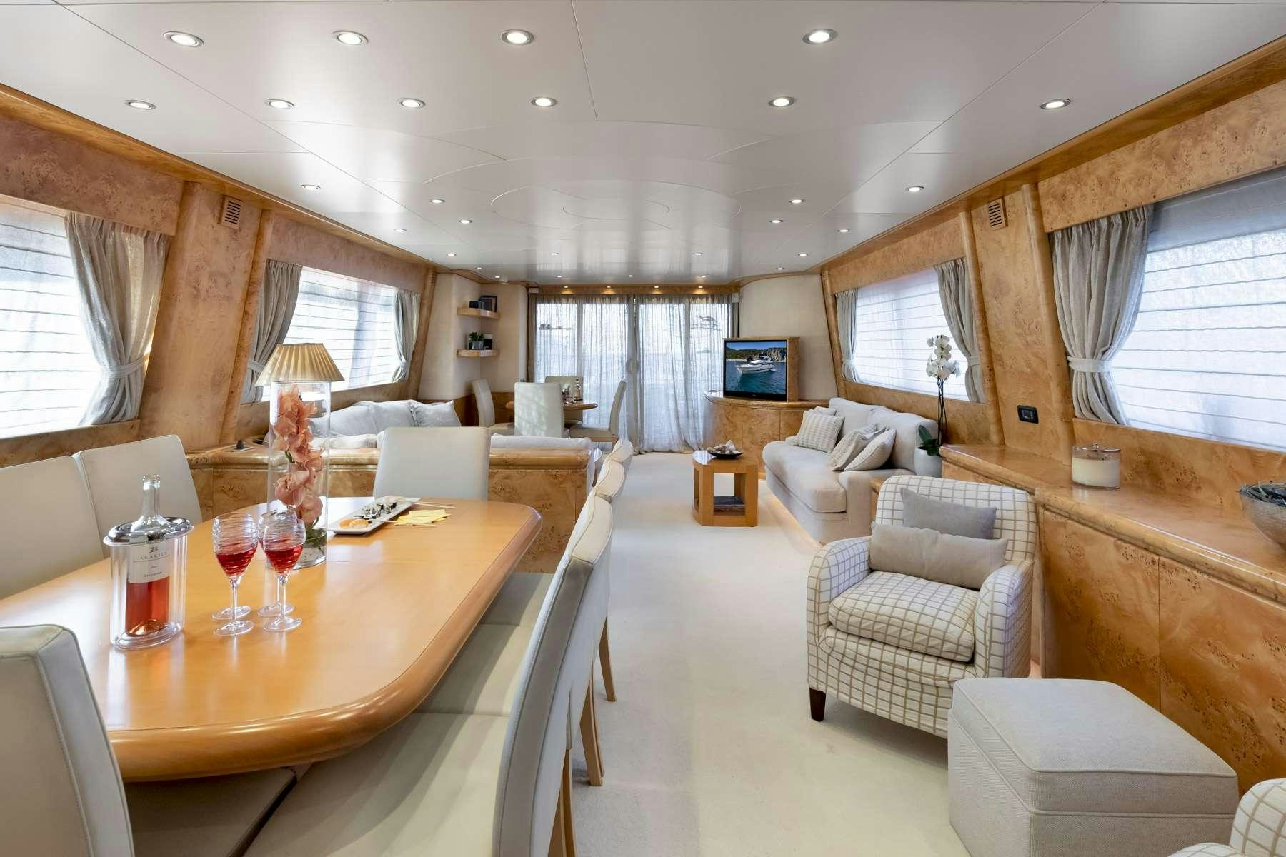 a living room with a table chairs and a couch aboard ANDILIS Yacht for Charter