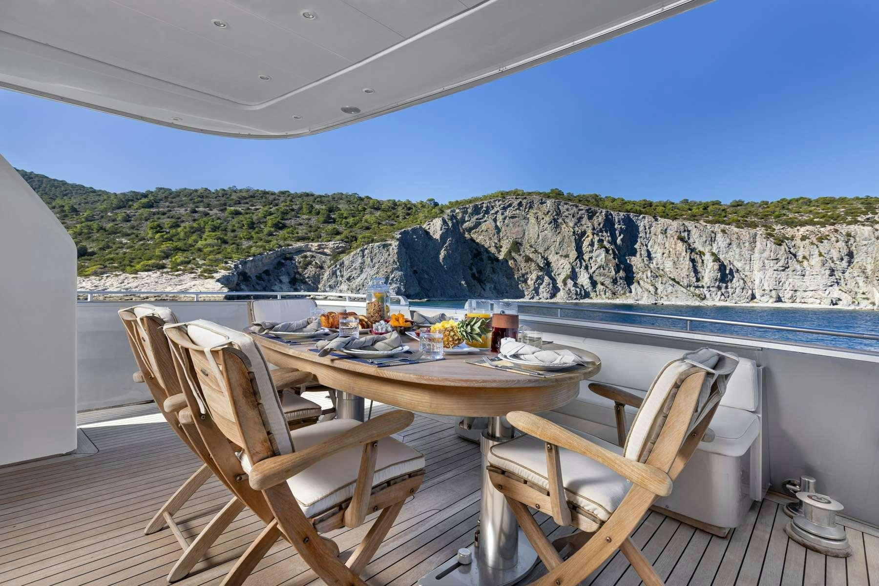 a table and chairs on a deck aboard ANDILIS Yacht for Charter