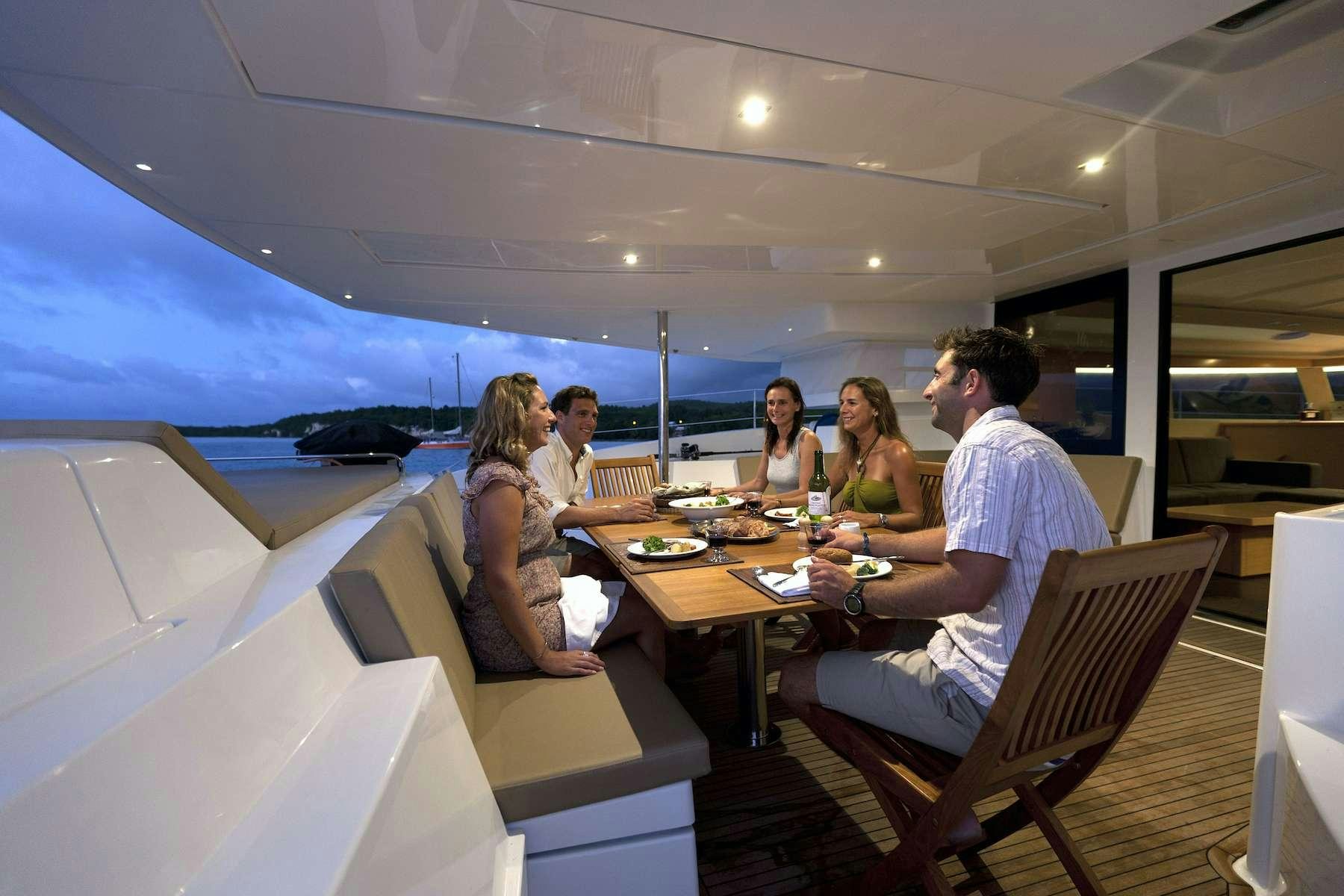 a group of people sitting around a table aboard TE MOANA - LUXURY TW59 Yacht for Charter