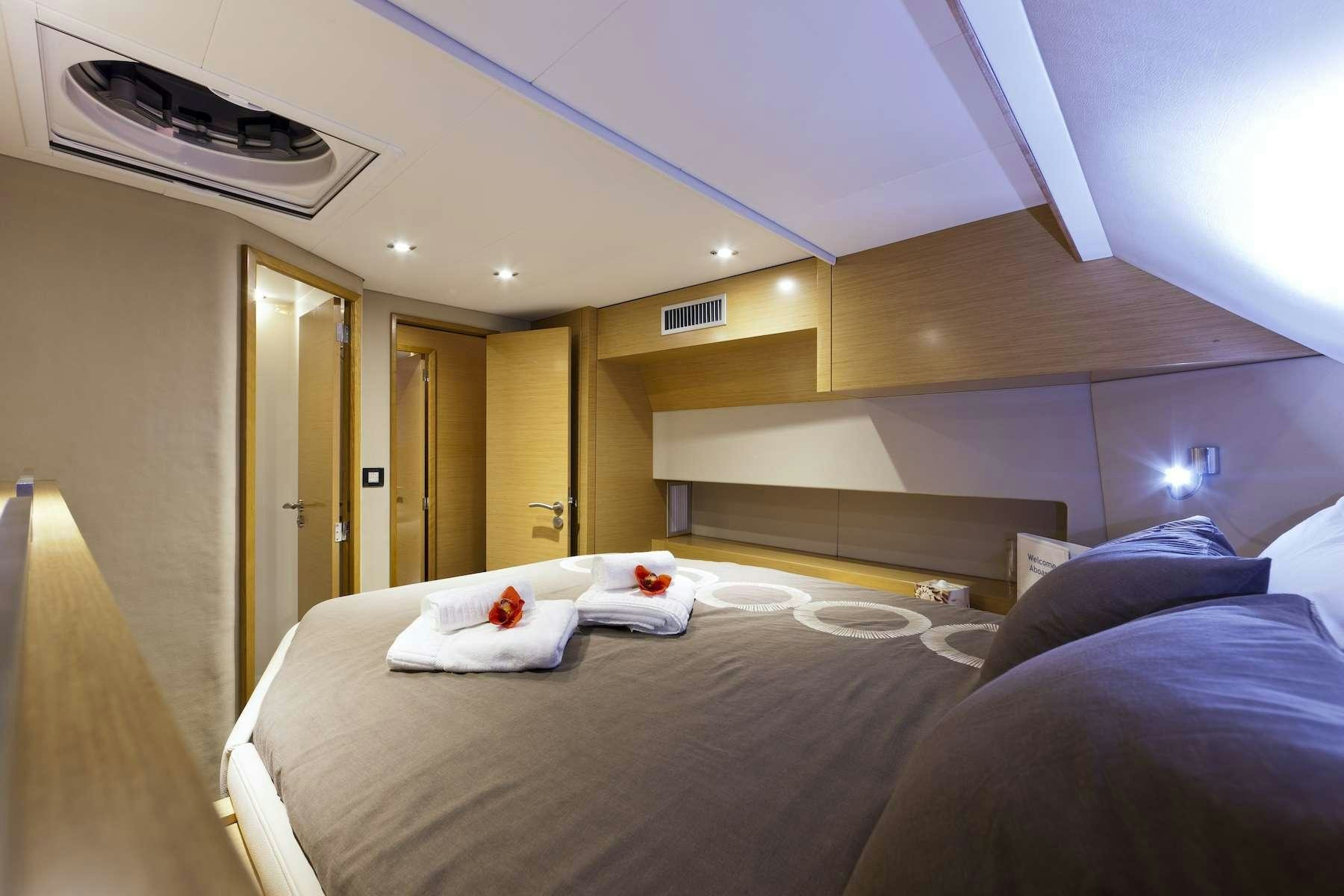 a room with a bed and a desk aboard TE MOANA - LUXURY TW59 Yacht for Charter