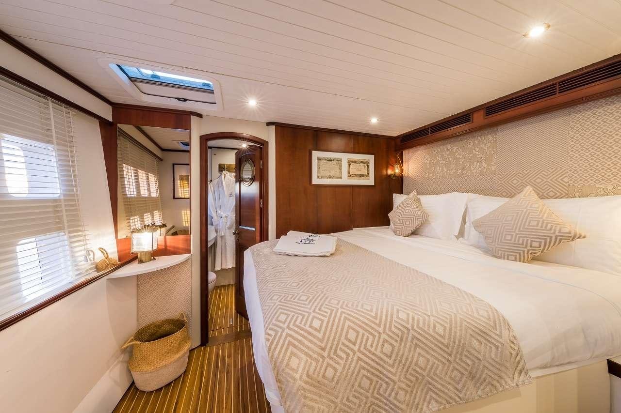 a bed with a white sheet and a white bed spread aboard OMBRE BLU³ Yacht for Charter