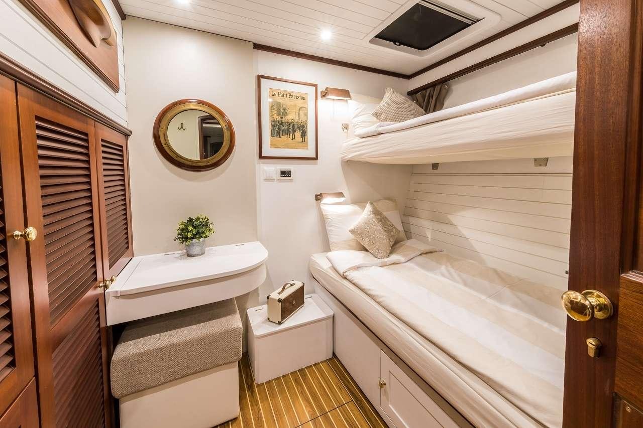 a room with a bed and a desk aboard OMBRE BLU³ Yacht for Charter
