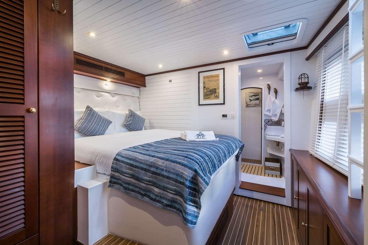 a bedroom with a bed and a desk aboard OMBRE BLU³ Yacht for Charter