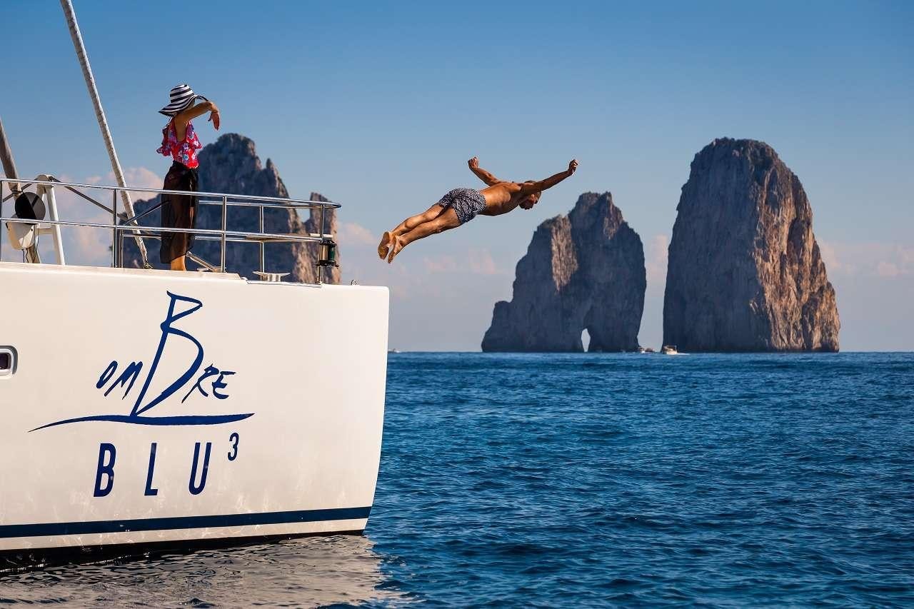 a man jumping off a boat aboard OMBRE BLU³ Yacht for Charter
