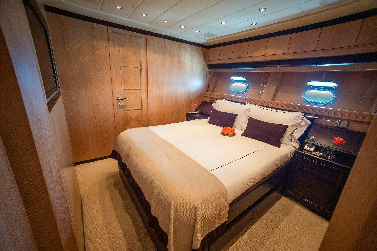 a room with a bed and a desk aboard FREE SPIRIT Yacht for Charter