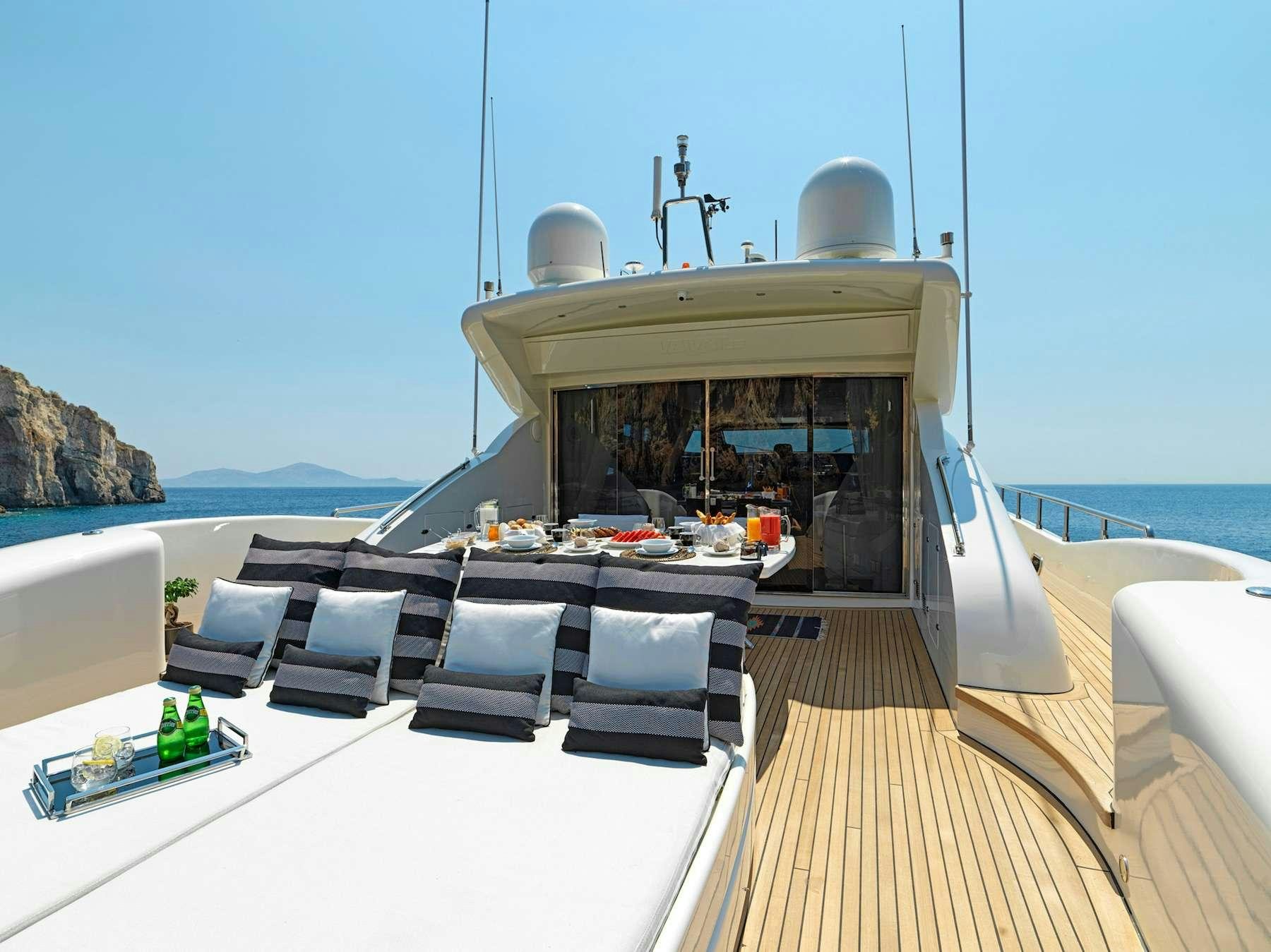 a deck with a table and chairs on it aboard RUBY Yacht for Charter