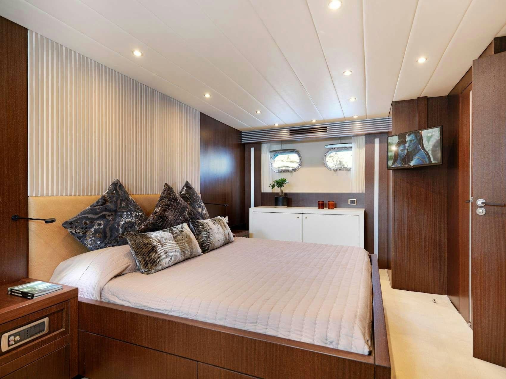 a bedroom with a bed and a desk aboard RUBY Yacht for Charter