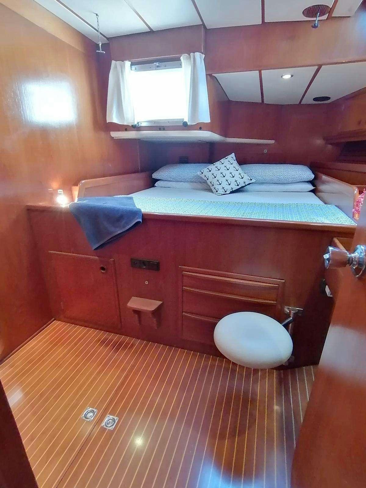 a bed with a blue blanket aboard AURORA Yacht for Charter