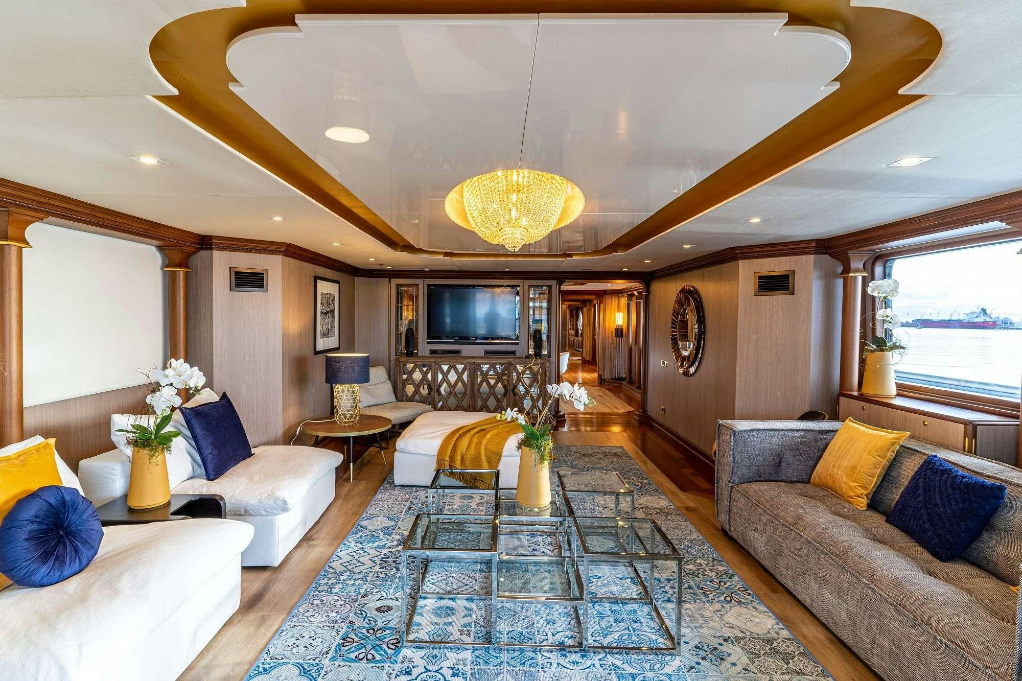 a living room with a large chandelier aboard IRAMA Yacht for Charter