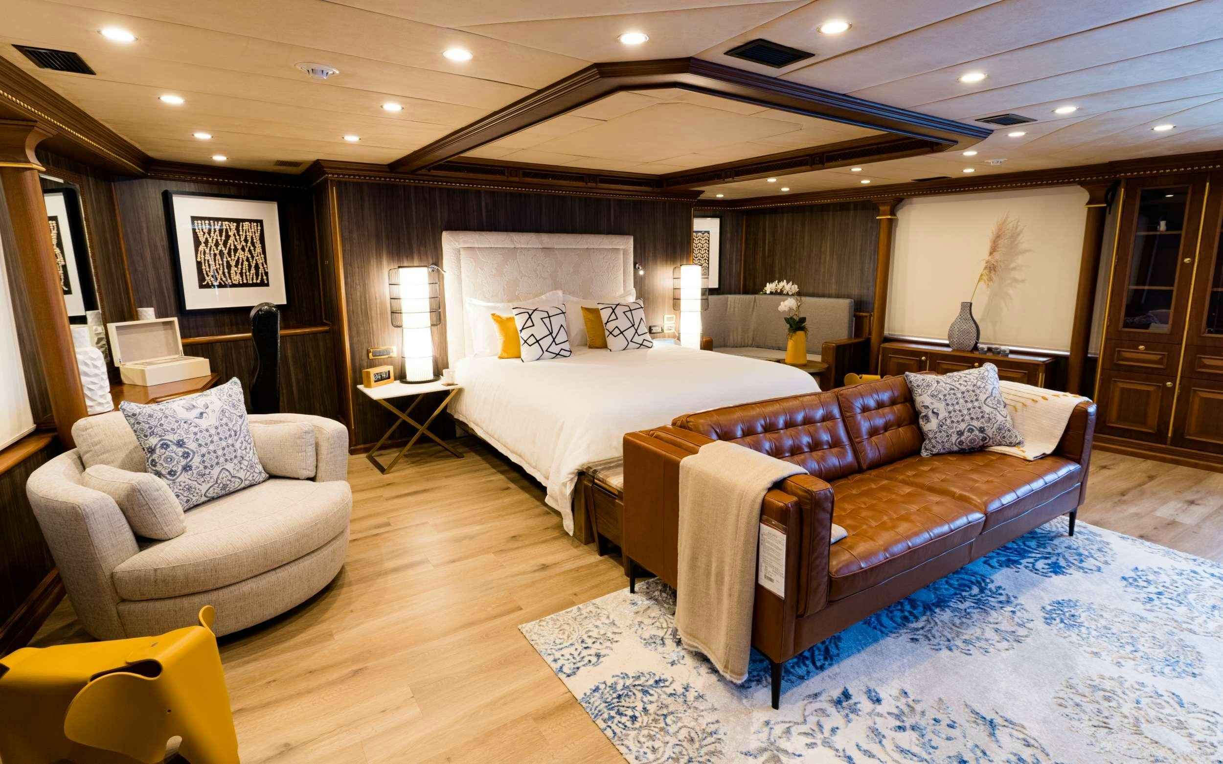 a room with a bed and a couch aboard IRAMA Yacht for Charter