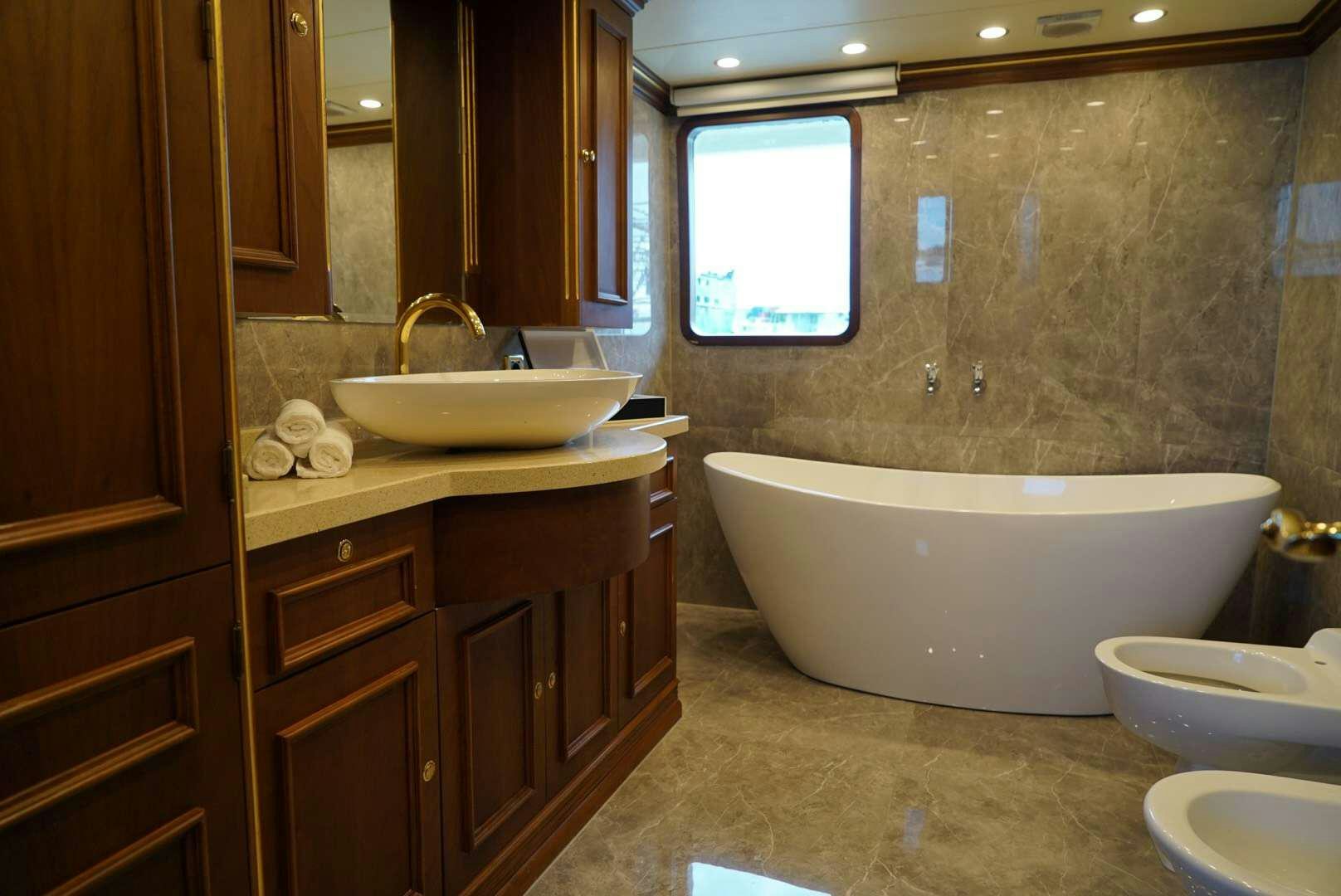 a bathroom with a tub sink and a sink aboard IRAMA Yacht for Charter