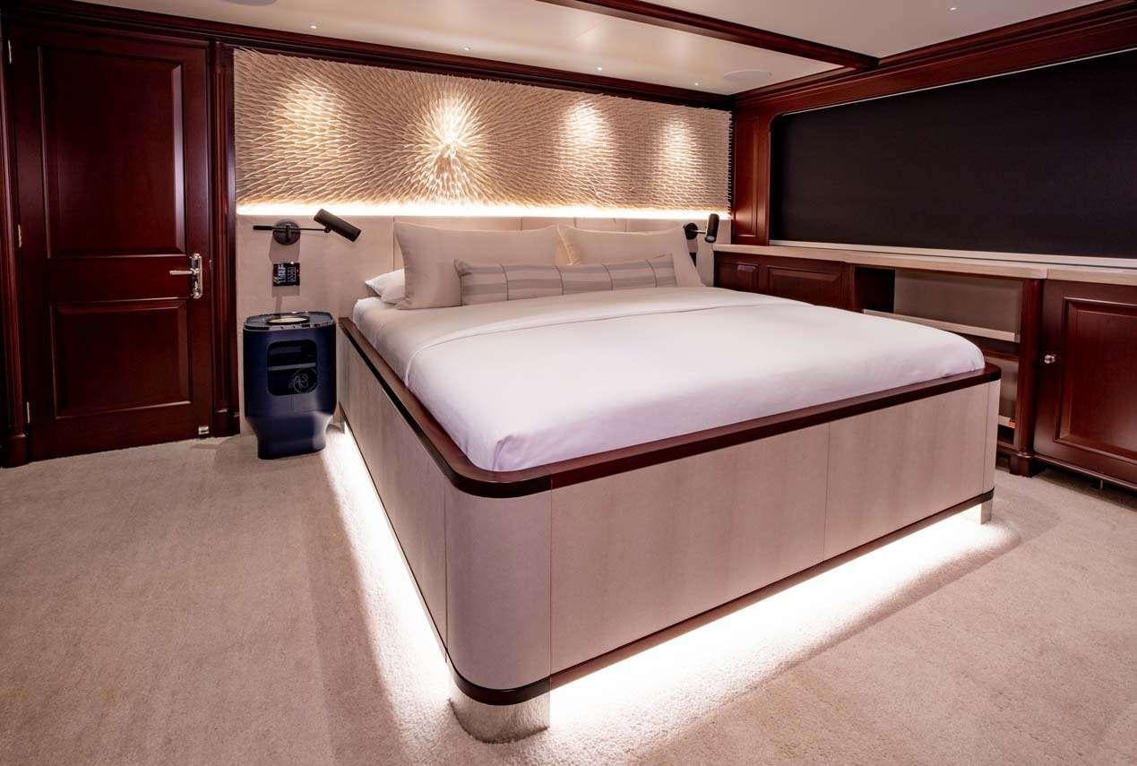 a room with a bed and a television aboard BROADWATER Yacht for Charter