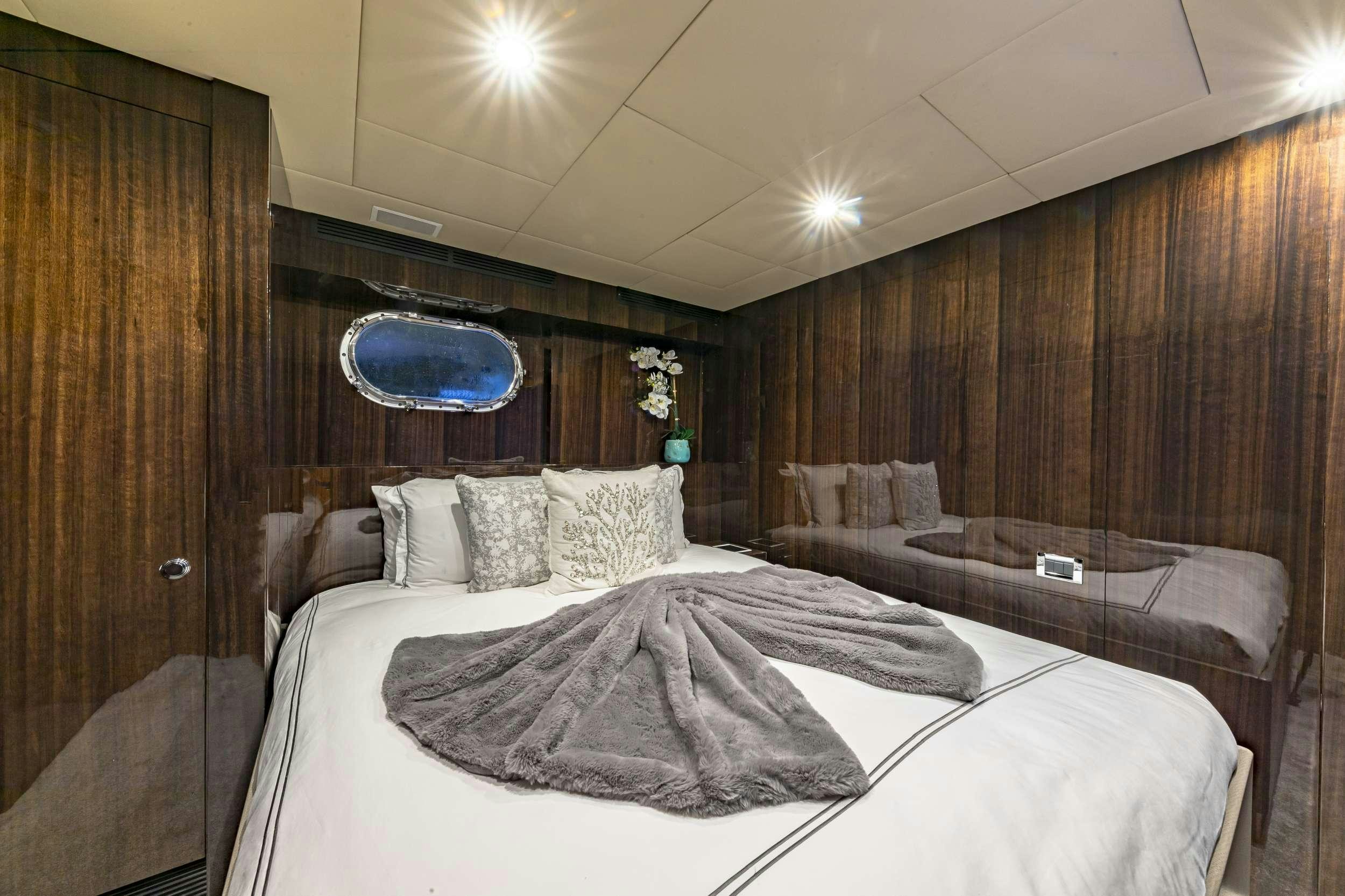 a room with a bed and a mirror aboard OCULUS Yacht for Charter