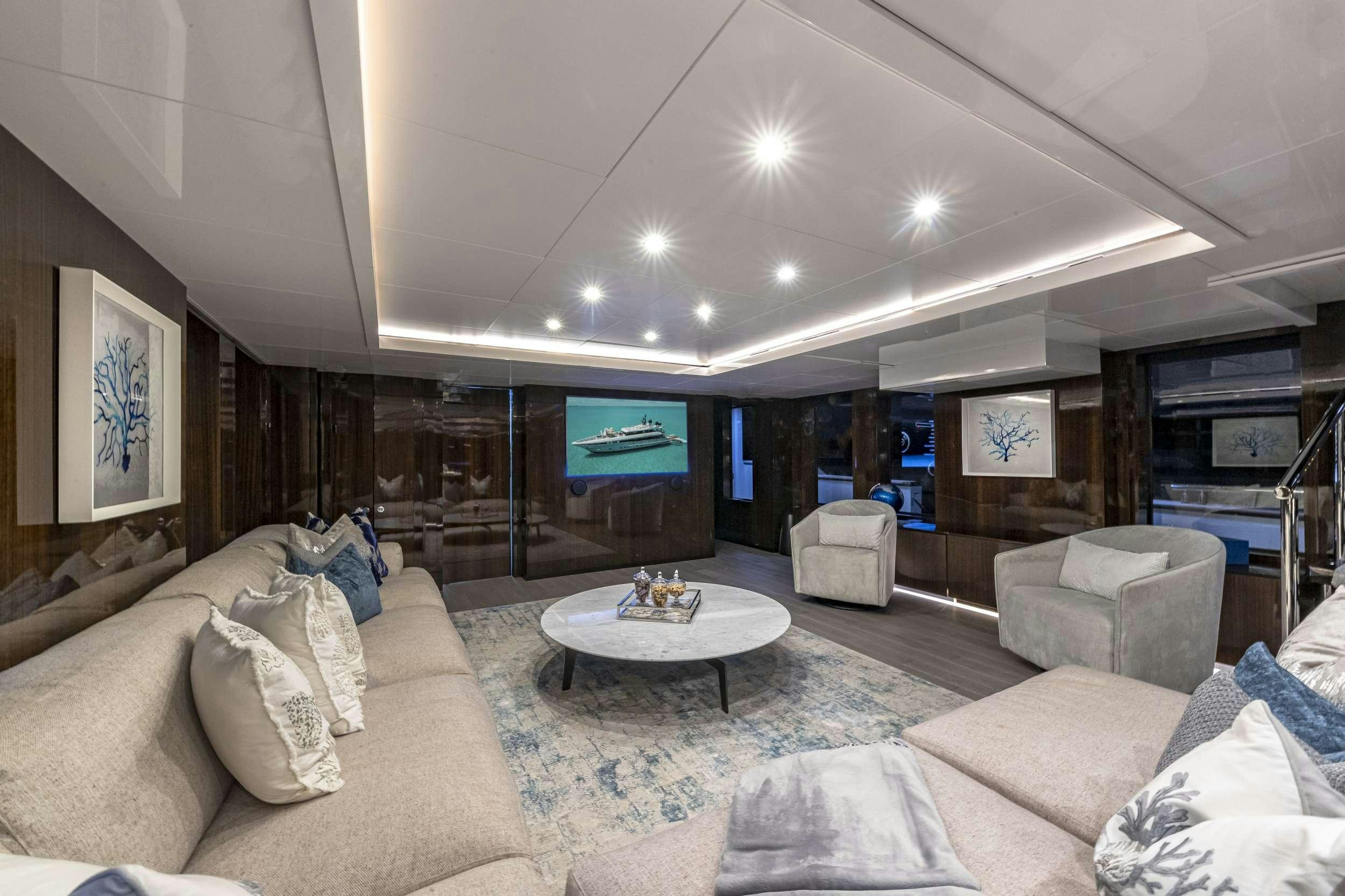 a living room with a large sofa and a table aboard OCULUS Yacht for Charter