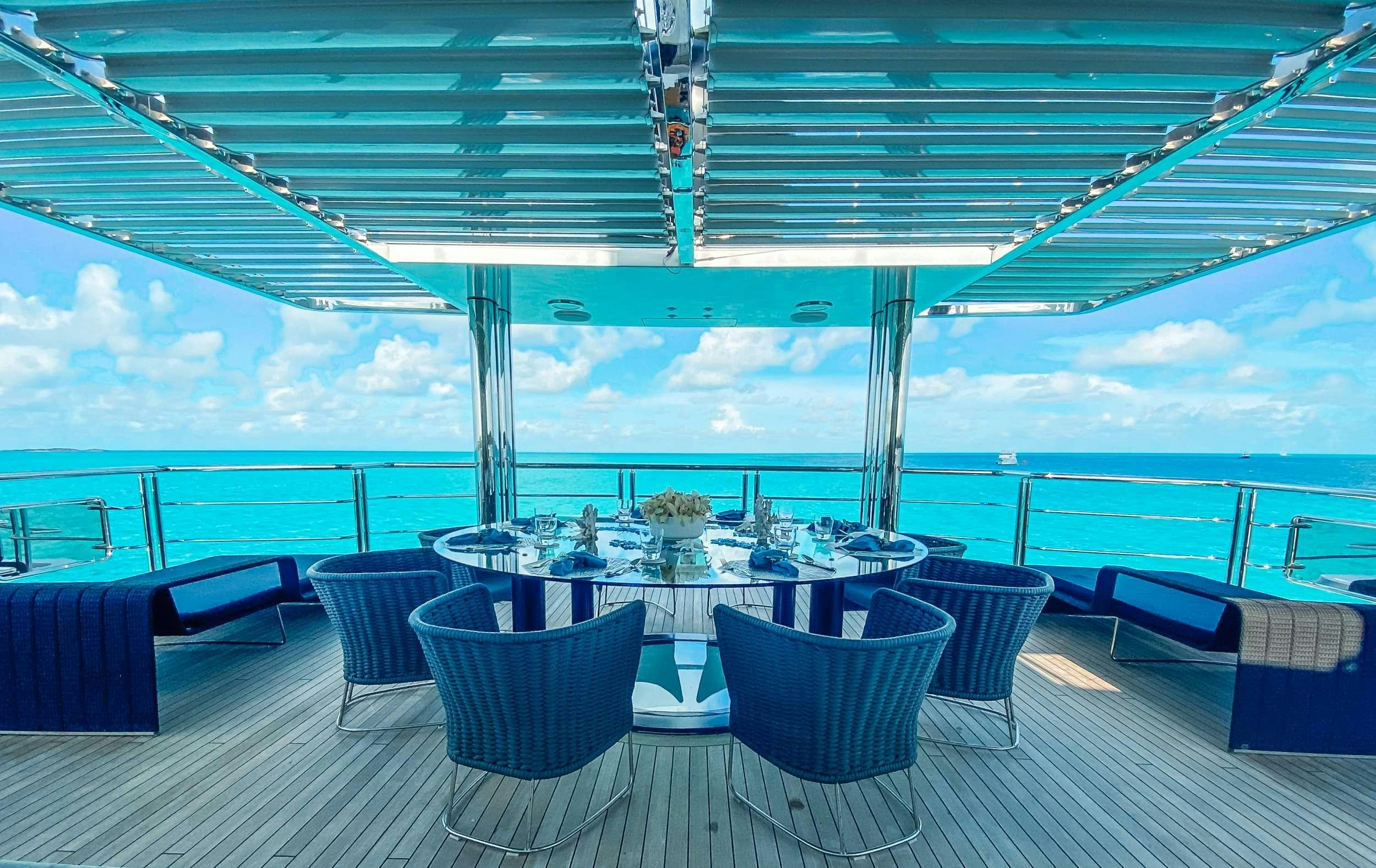 a table and chairs on a deck aboard OCULUS Yacht for Charter