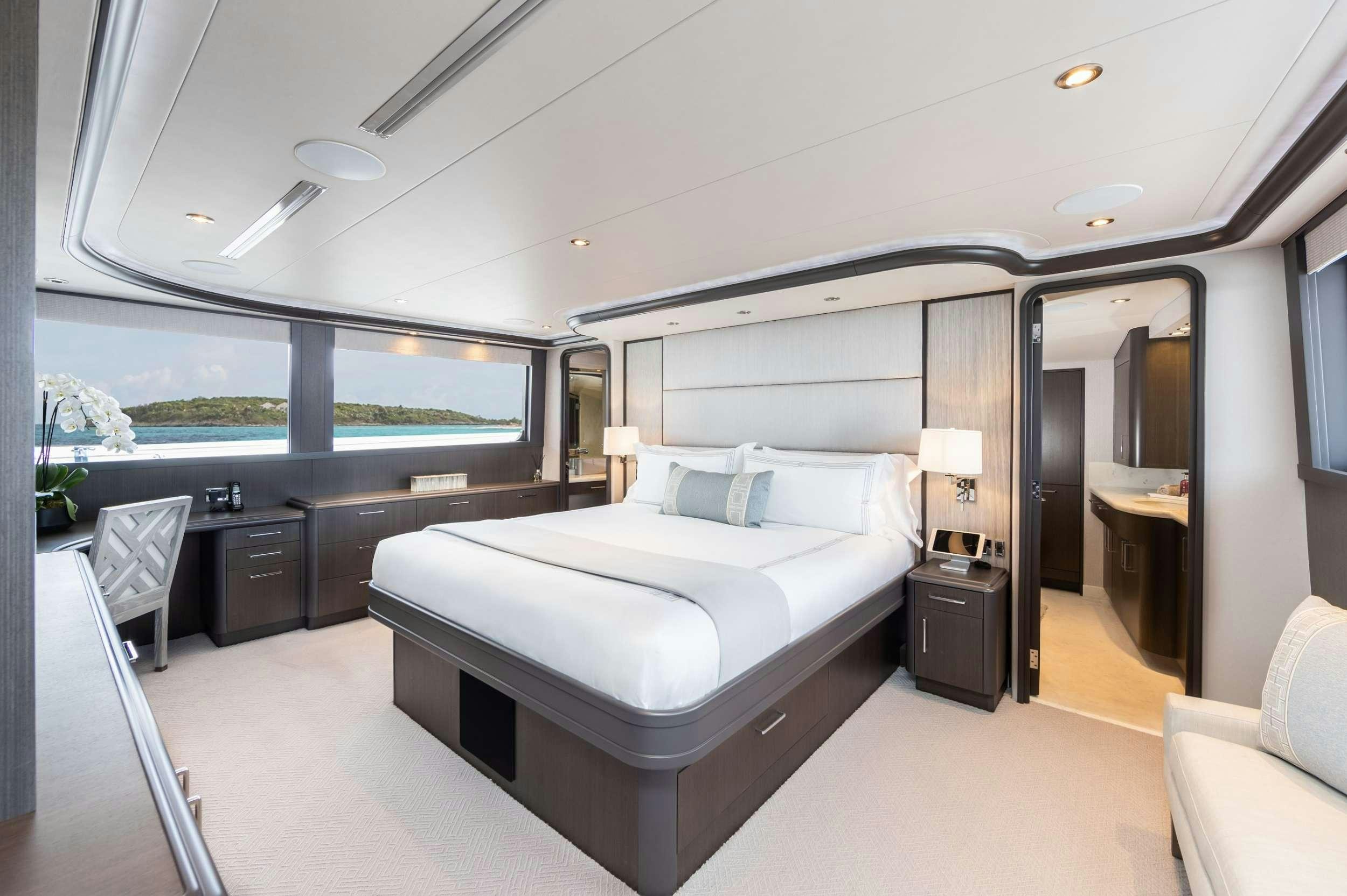 a room with a bed and a large window aboard NO BAD IDEAS Yacht for Charter