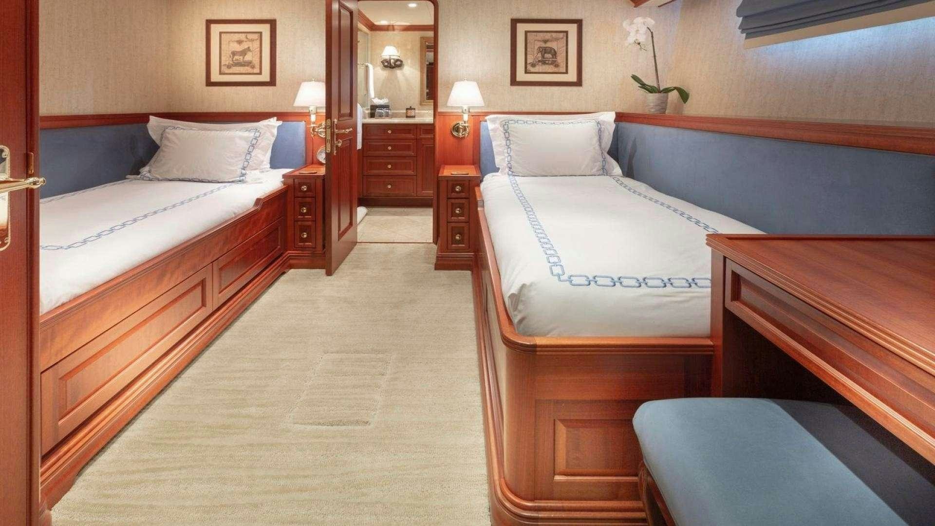 a room with beds and a mirror aboard IMPETUOUS Yacht for Charter