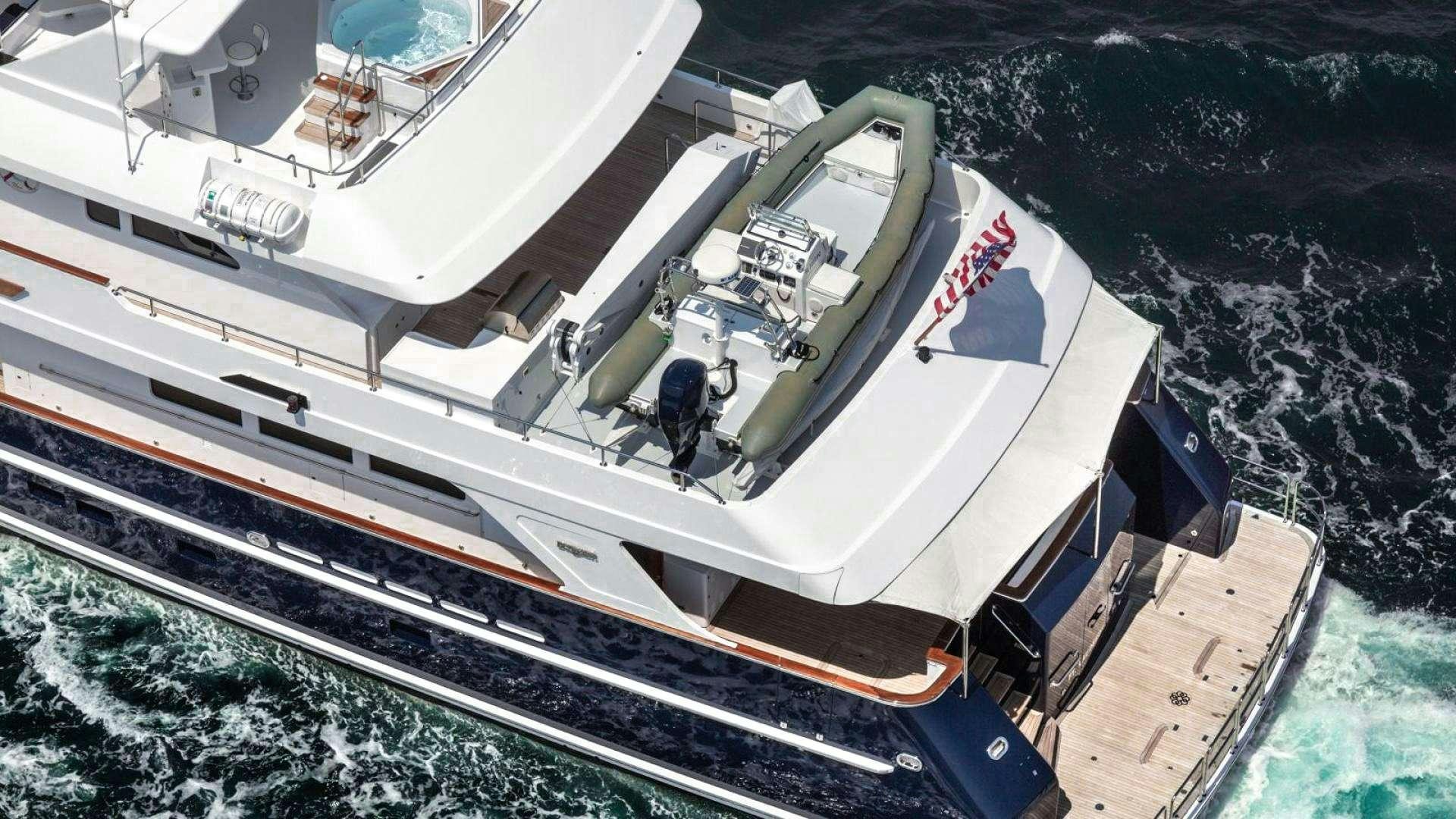 a large white boat with a person standing on it aboard IMPETUOUS Yacht for Charter
