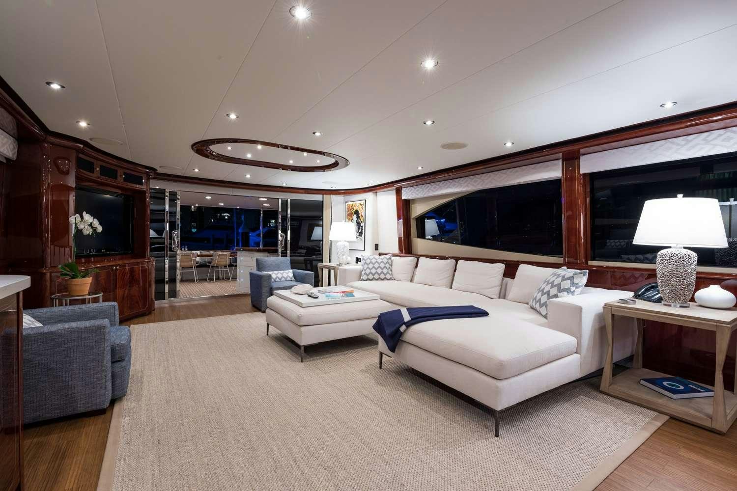 a living room with a large white couch and a large window aboard QTR Yacht for Charter
