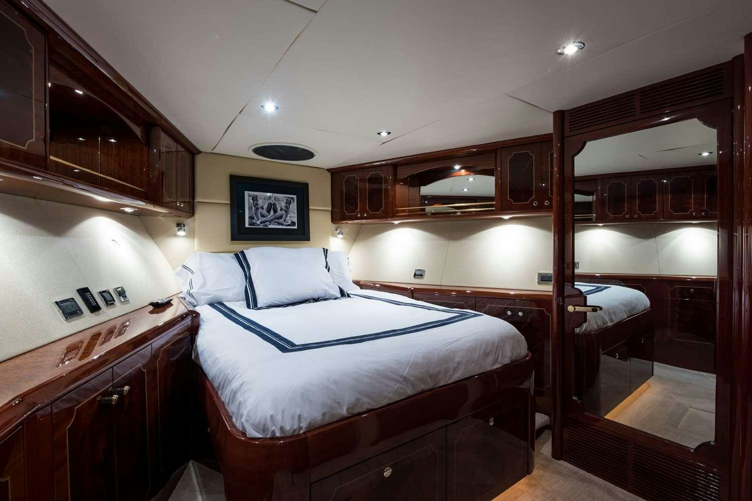 a bedroom with wood cabinets aboard QTR Yacht for Charter