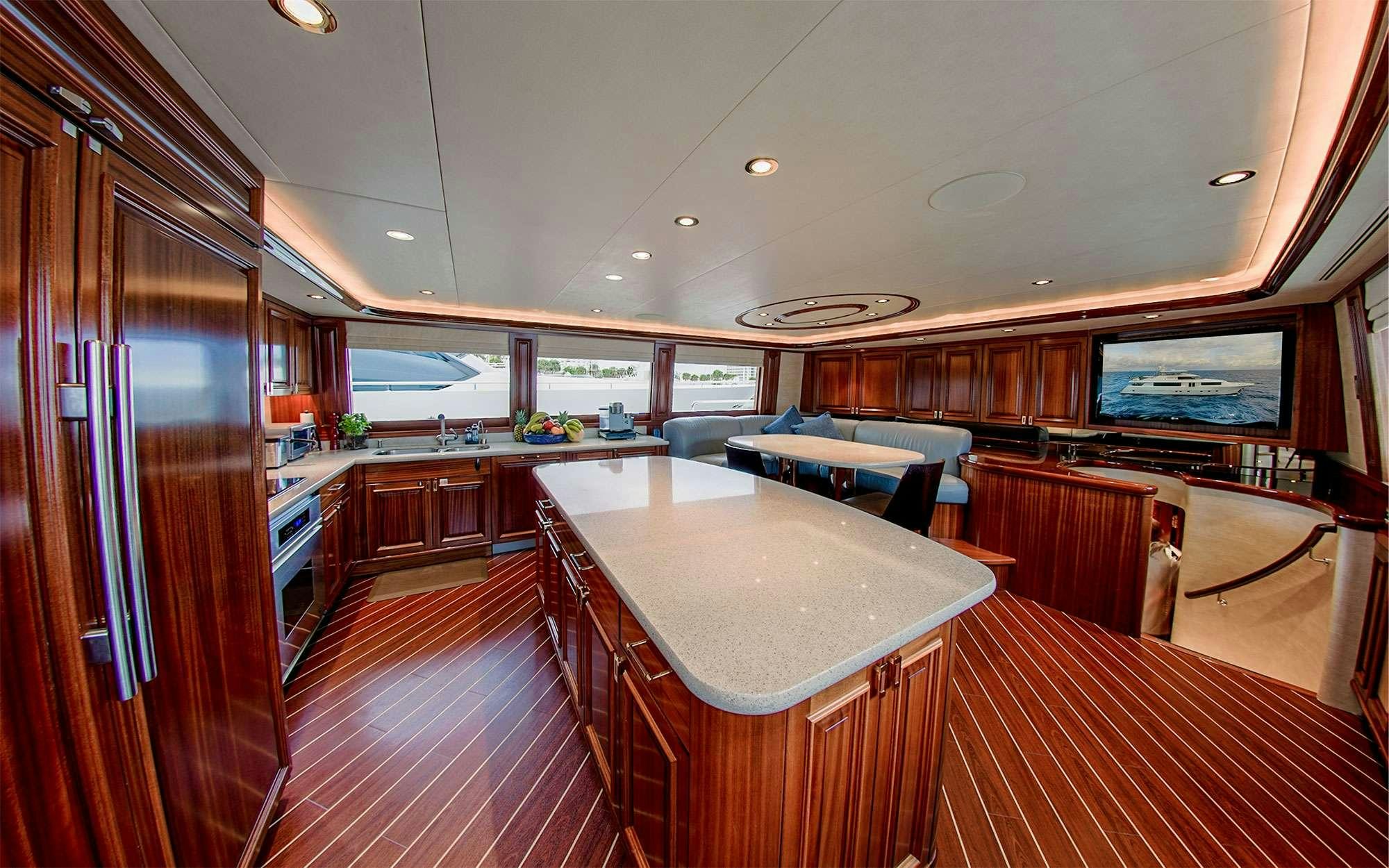 a large kitchen with a bar and a large table aboard JEANNIETINI Yacht for Charter