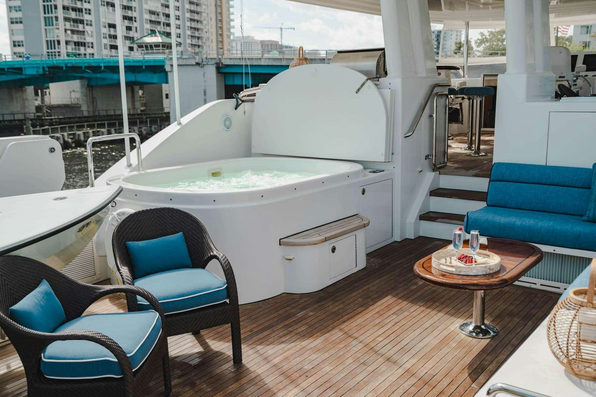 a white bathtub in a room with chairs and a table aboard NOW OR NEVER Yacht for Charter