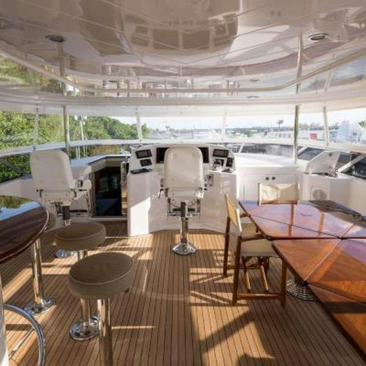 a room with tables and chairs aboard NATURAL 9 Yacht for Charter