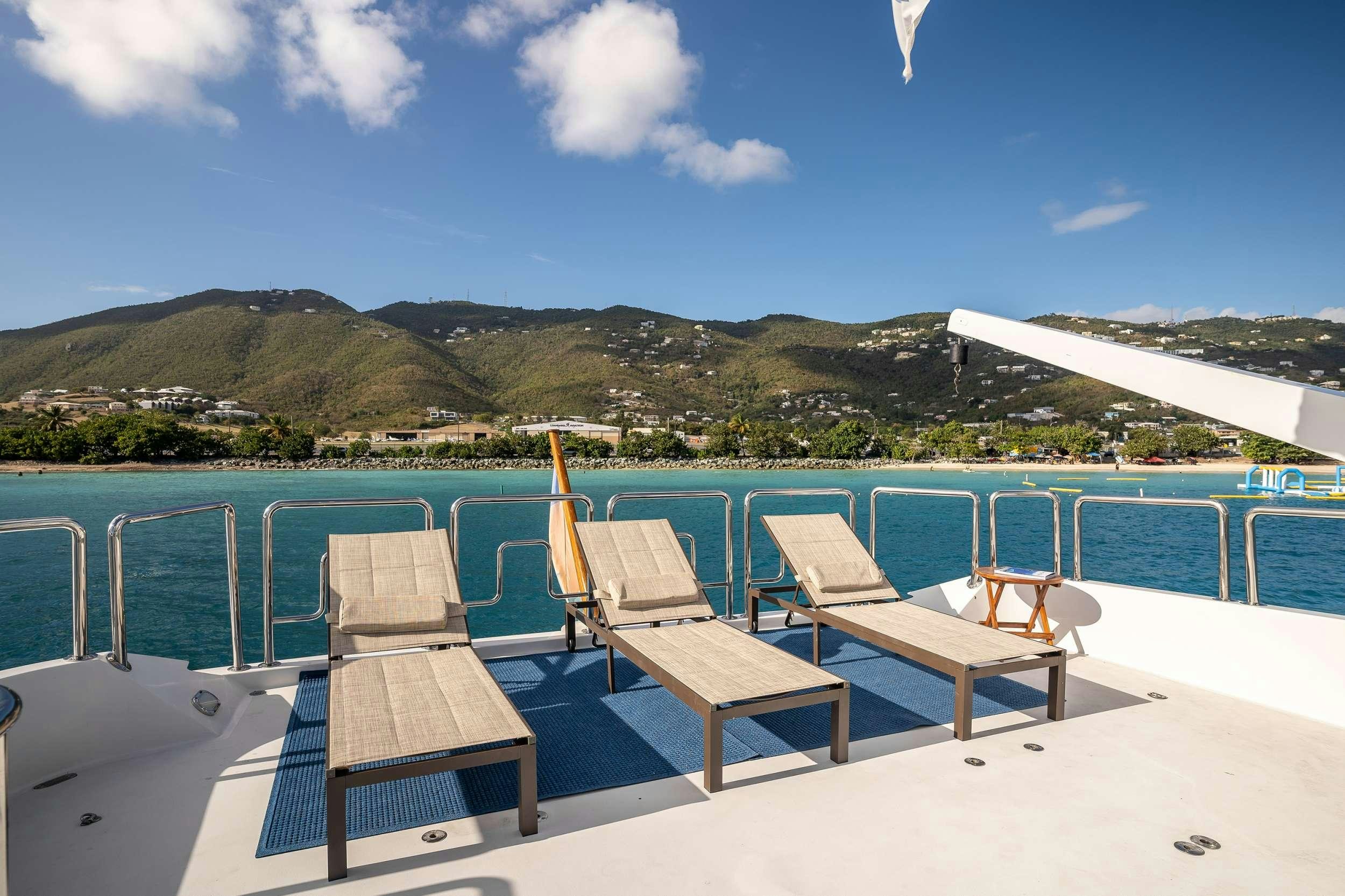 a group of chairs on a deck overlooking a body of water aboard OUTTA TOUCH Yacht for Charter