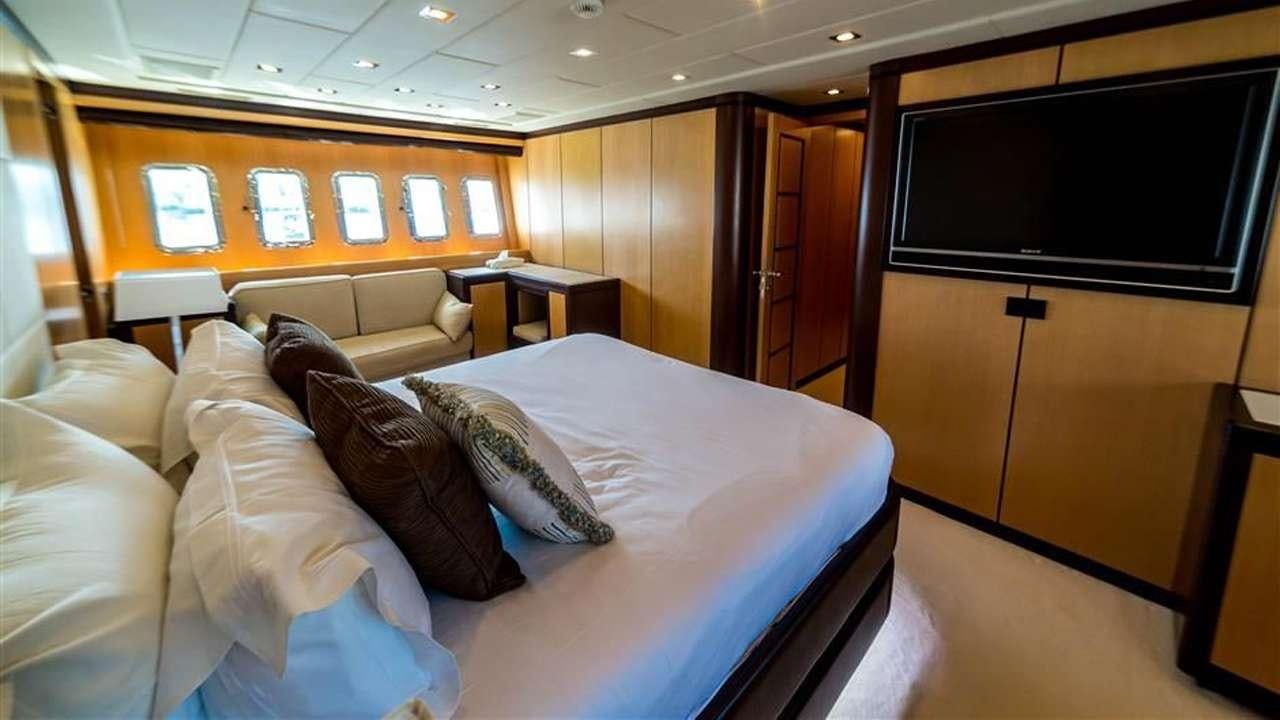 a hotel room with a bed and a tv aboard DAYA Yacht for Charter
