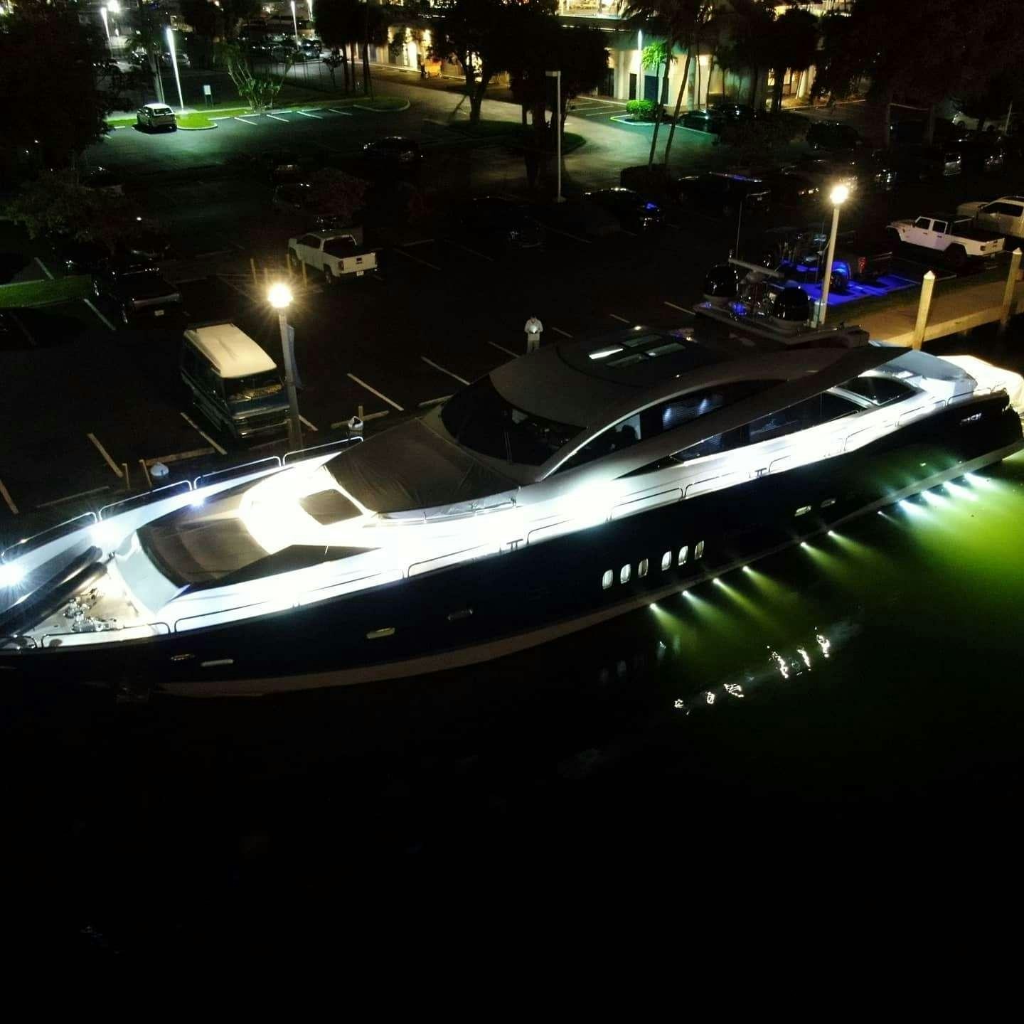 a white boat on a dock at night aboard sky fall Yacht for Charter