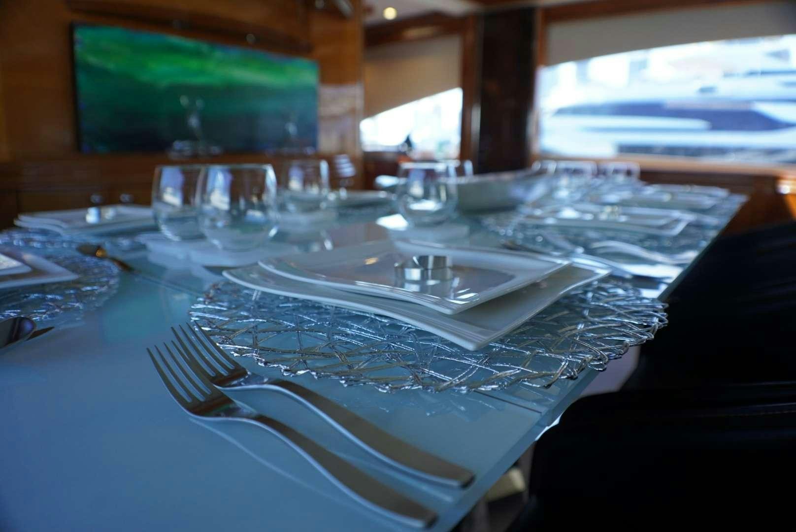 a table with a plate and glasses aboard YCM 105 Yacht for Charter