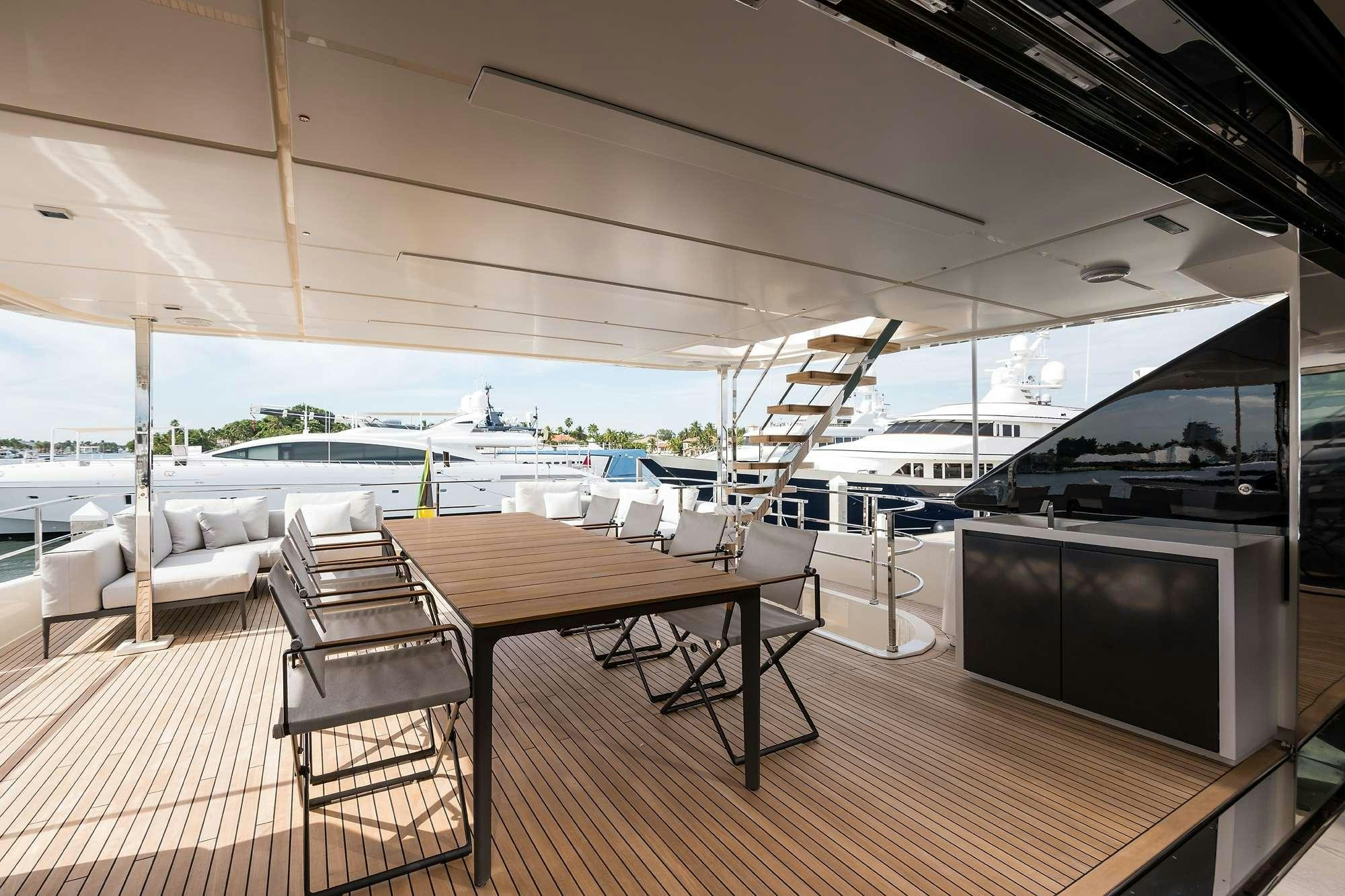 a deck with a table and chairs aboard GIOIA Yacht for Charter