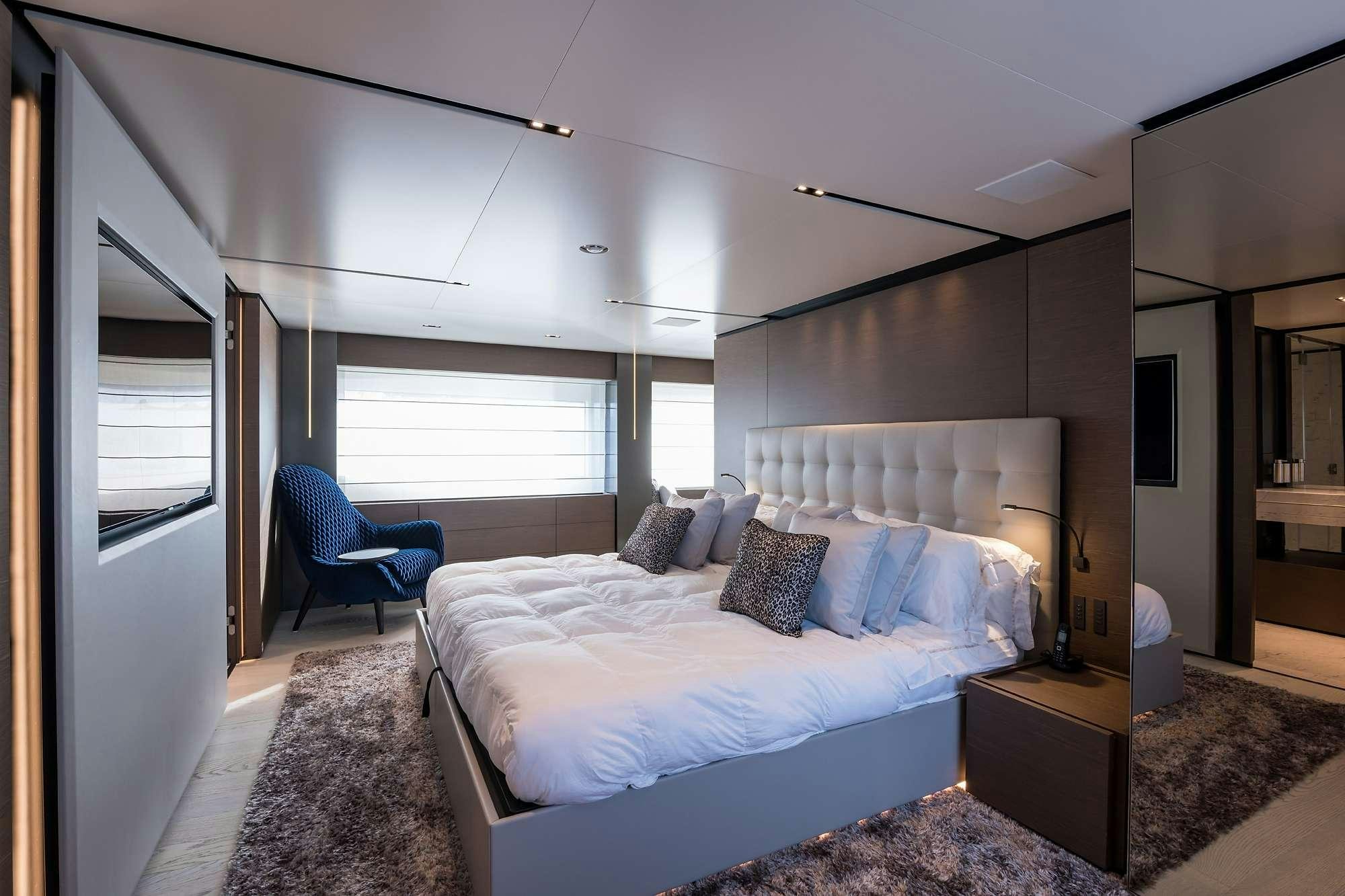 a bedroom with a bed and a chair aboard GIOIA Yacht for Charter