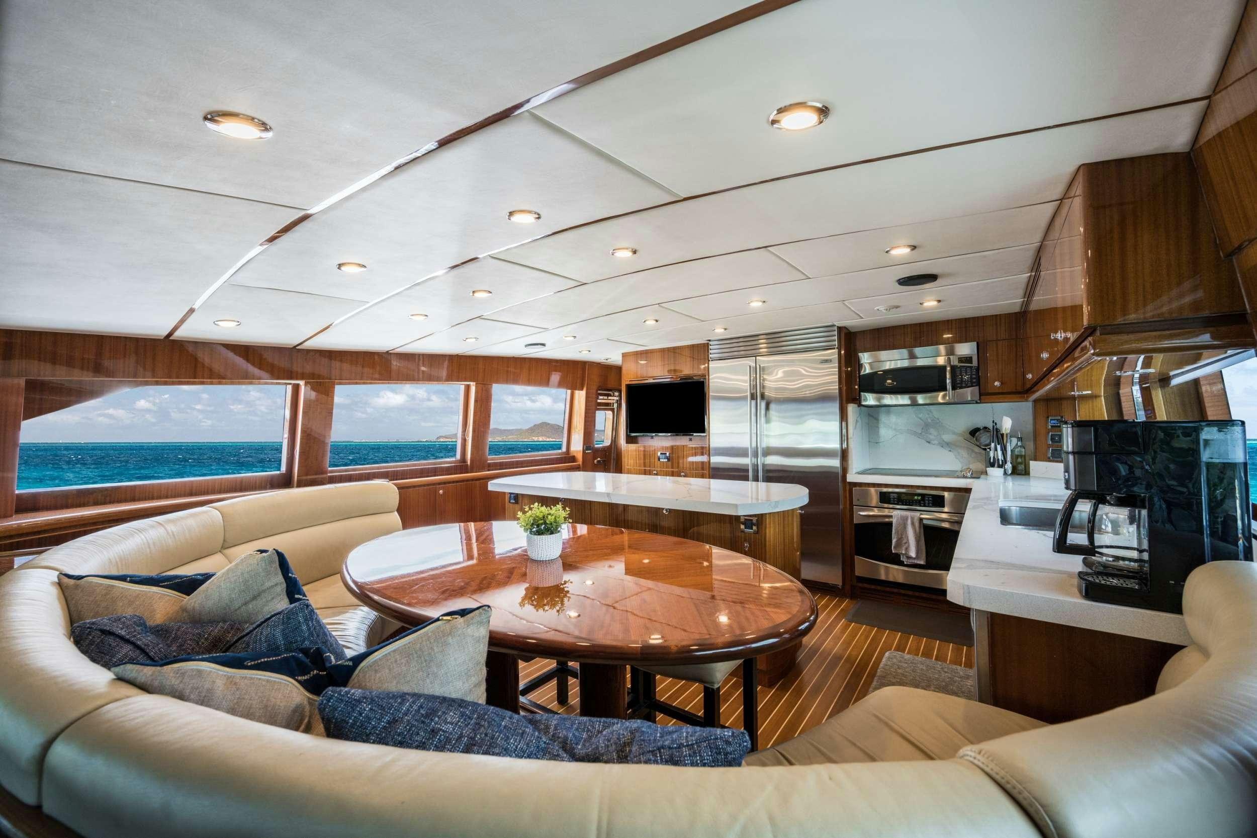 a living room with a table and couches aboard LIMITLESS Yacht for Charter
